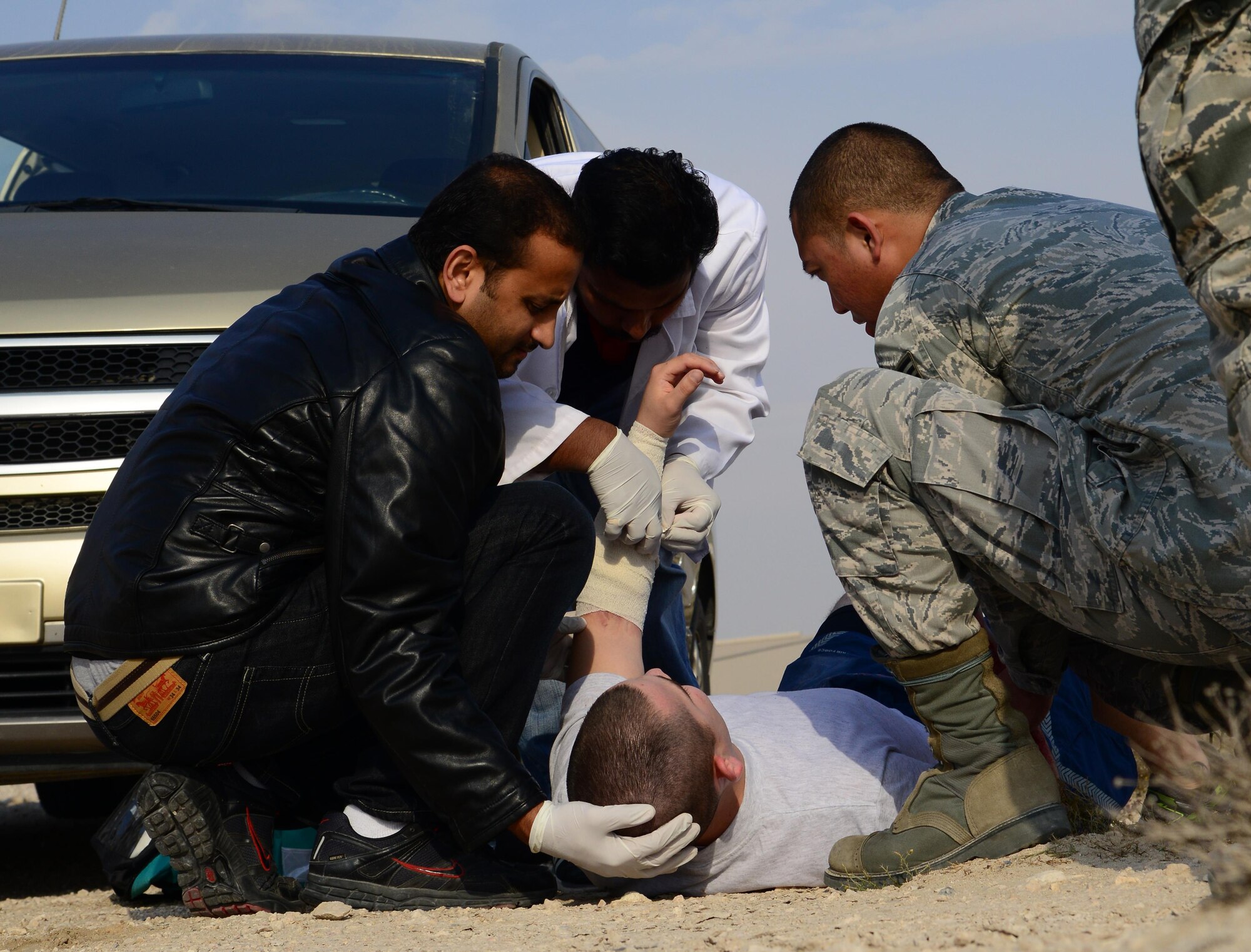 U.S. Air Force Senior Airman Edisitio Mendoza, right, 379th Expeditionary Medical Operations Squadron, works alongside Qatari medical counterparts to provide care to simulated victims of a motor vehicle accident during a joint training event, Jan. 18, 2015, at Al Udeid Air Base, Qatar. The training required 379th Expeditionary Medical Group Airmen and Qatari medics to integrate and exchange knowledge that will help them jointly respond to real-world medical emergencies at Al Udeid. (U.S. Air Force photo by Senior Airman Kia Atkins)