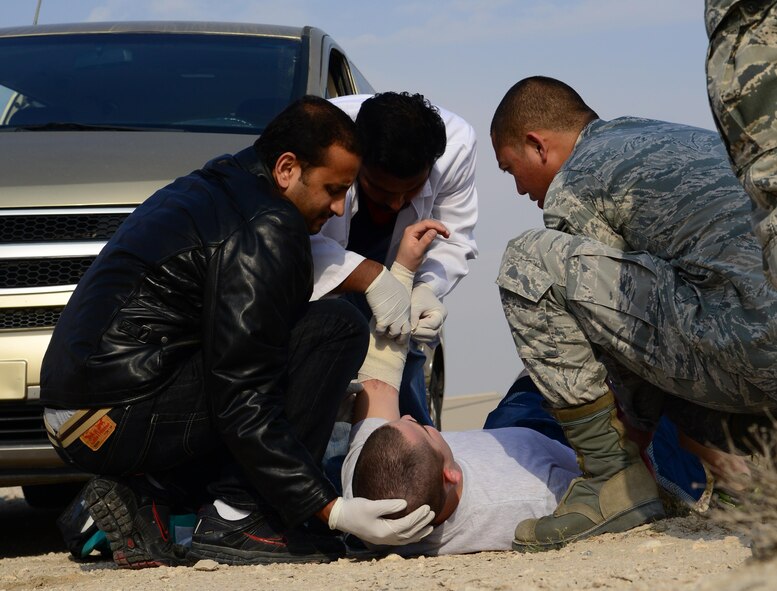 U.S. Air Force Senior Airman Edisitio Mendoza, right, 379th Expeditionary Medical Operations Squadron, works alongside Qatari medical counterparts to provide care to simulated victims of a motor vehicle accident during a joint training event, Jan. 18, 2015, at Al Udeid Air Base, Qatar. The training required 379th Expeditionary Medical Group Airmen and Qatari medics to integrate and exchange knowledge that will help them jointly respond to real-world medical emergencies at Al Udeid. (U.S. Air Force photo by Senior Airman Kia Atkins)