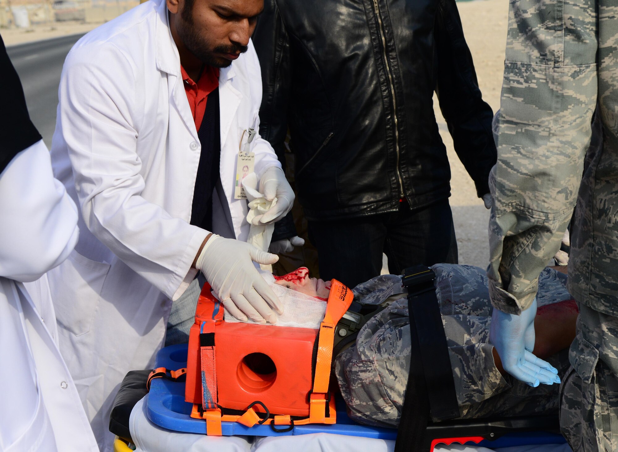 U.S. Air Force and Qatari medical personnel prepare to transport a simulated victim of a motor vehicle accident to the 379th Expeditionary Medical Group during a joint training event, Jan. 18, 2015, at Al Udeid Air Base, Qatar. The training required 379th EMDG Airmen and Qatari medics to integrate and exchange knowledge that will help them jointly respond to real-world medical emergencies at Al Udeid. (U.S. Air Force photo by Senior Airman Kia Atkins)