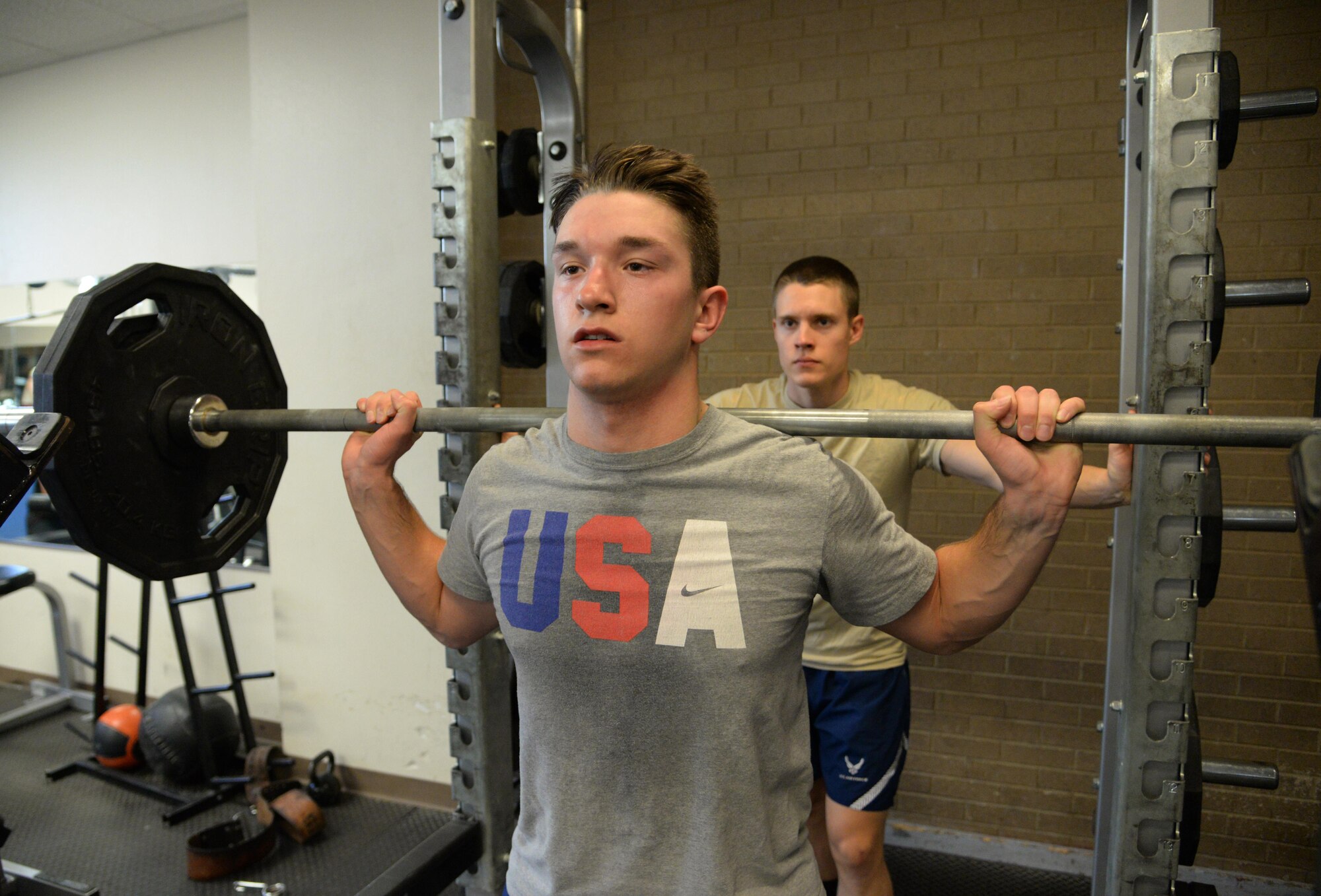 U.S. Air Force Airmen 1st Class Derek Slack and John Takats, 27th Special Operations Contracting Squadron, spot each other during an organized physical training session at the Fitness Center Jan. 20, 2015 at Cannon Air Force Base, N.M. The squadron gathers several times per week to help maintain fitness standards. (U.S. Air Force photo/Staff Sgt. Alexxis Mercer)    