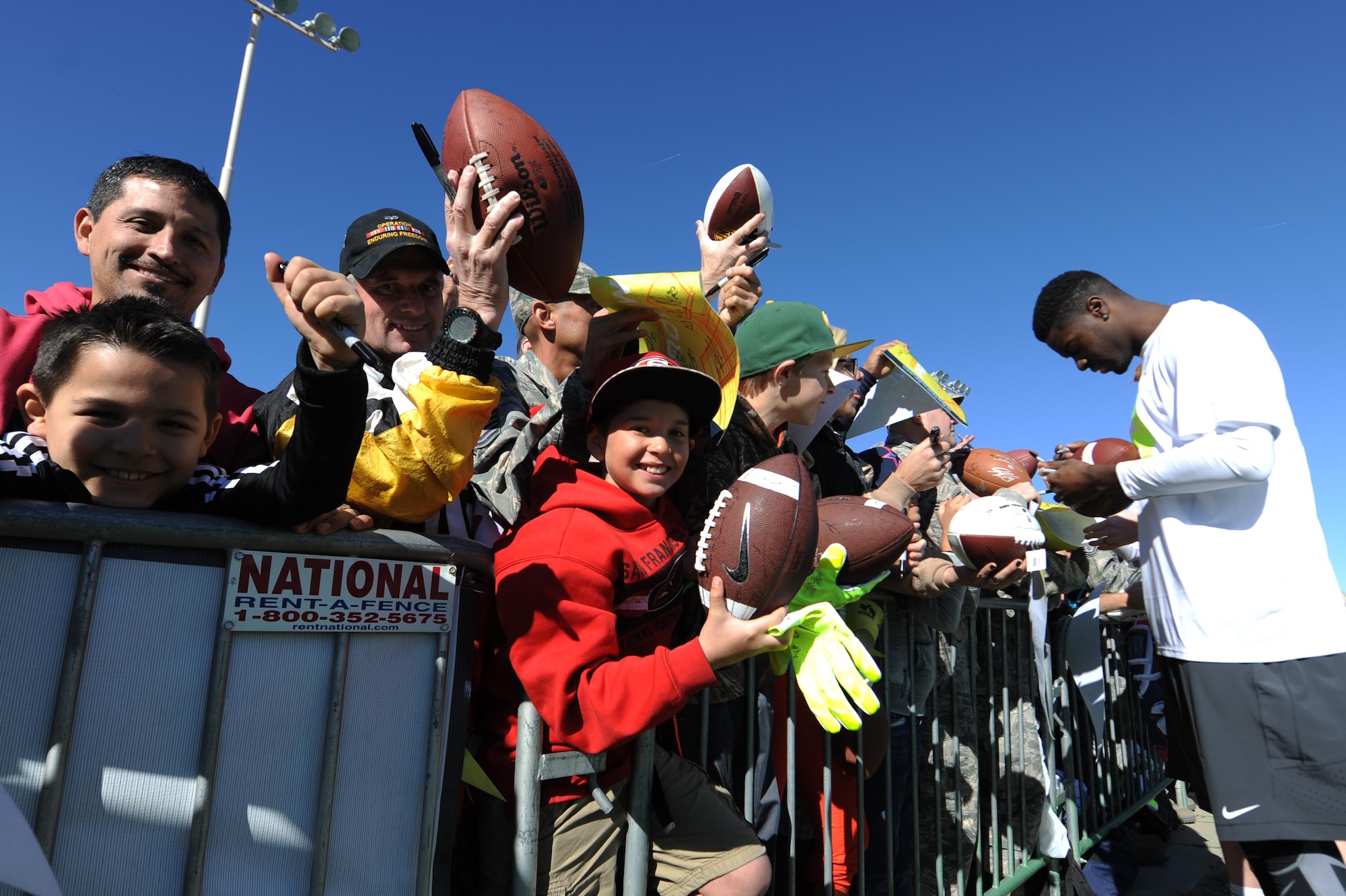 A.J. Green, Cincinnati Bengals wide receiver assigned to Pro Bowl Team Carter, autographs footballs and pendants during the Pro Bowl practice at Luke Air Force Base, Arizona, Jan. 22, 2015. The Pro Bowl players were practicing on base to show support for Airmen and to prepare for the game on Sunday. (U.S. Air Force photo by Staff Sgt. Staci Miller)