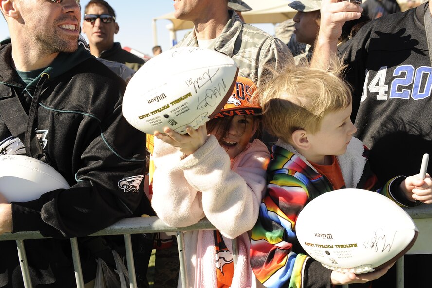 Fans hold up autographed footballs at the Pro Bowl practice at Luke Air Force Base, Arizona, Jan. 22, 2015. The Pro Bowl players came out to Luke to show support for the Airmen and their families. The players took photos with the Airmen and did autographs for them as well. (U.S. Air Force photo by Staff Sgt. Staci Miller)