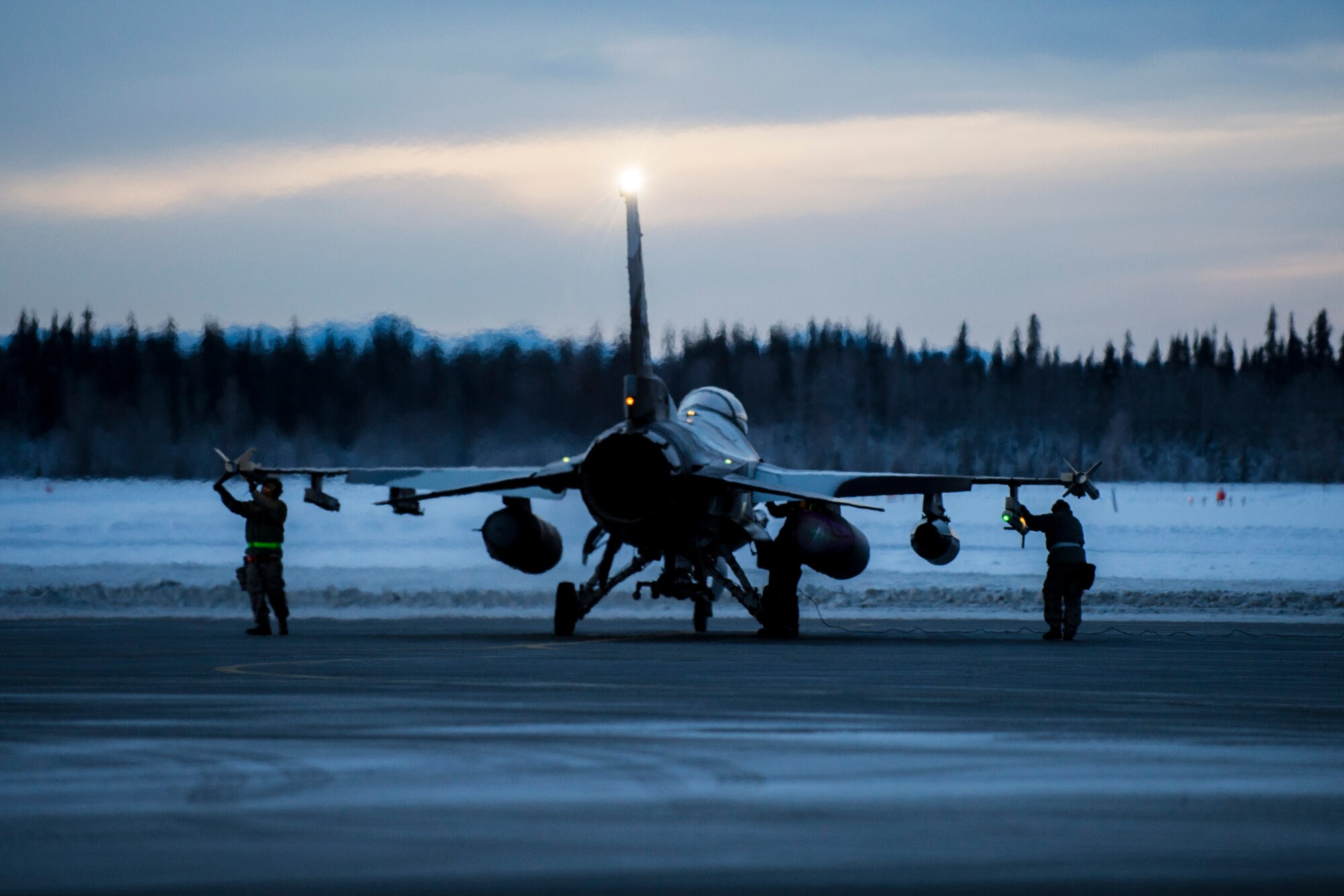 Airmen prepare an F-16 Fighting Falcon aircraft Jan. 17, 2015, on Eielson Air Force Base, Alaska, in transit to Joint Base Pearl Harbor-Hickam, Hawaii, and Andersen Air Force Base, Guam. More than 150 maintainers will keep the 18th Aggressor Squadron in the air during Pacific Air Forces exercises, which are meant to prepare Airmen, Sailors and Marines, along with coalition partners in the Pacific theater, of operations for contingency operations if the need arises. The Airmen are from the 354th Aircraft Maintenance Squadron. (U.S. Air Force photo/Staff Sgt. Joshua Turner)