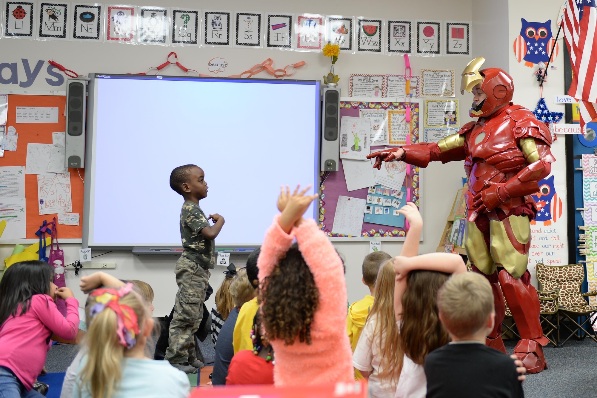 Tech. Sgt. Brian Thornton engages with children while dressed up in his homemade Iron Man suit  Dec. 8, 2014, at Marrington Elementary, Joint Base Charleston - Weapons Station, S.C. Thornton wears his Iron Man suit at local schools and hospitals hoping to help brighten a children’s days. Thornton is a 628th Air Base Wing Air Defense Council paralegal.  (U.S. Air Force photo/Senior Airman Christopher Reel)
