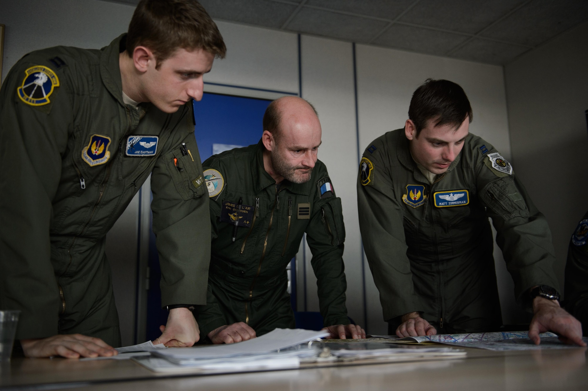 Two U.S. Air Force pilots and a French air force navigator discuss the route to the drop zone during a simulated low-level drop Jan. 21, 2015, at Orleans - Bricy Air Base, France. The drop is one of many events during exercise Volfa 15-1, a French-led exercise designed to improve tactical airlift and fighter squadron operation between allied countries. (U.S. Air Force photo/Senior Airman Armando A. Schwier-Morales)