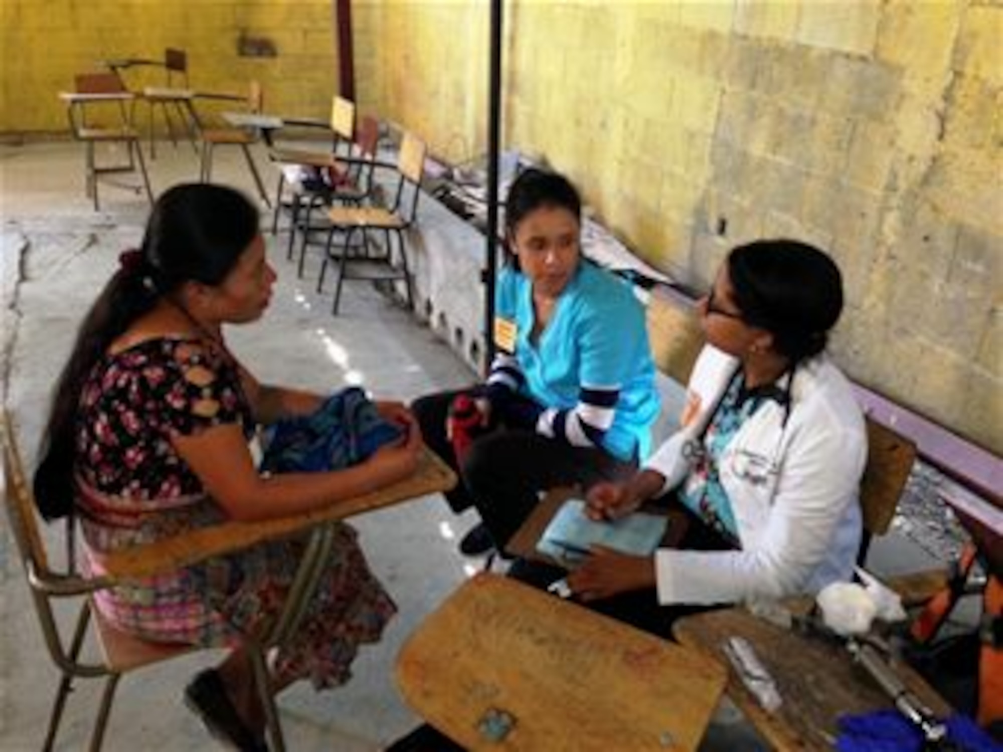 In a village near San Raimundo Guatemala, physician assistant Paree Gallo (white coat) with T.I.M.E. for Christ Medical Ministries interviews a female patient with Juany Rodriguez (right) a translator. 