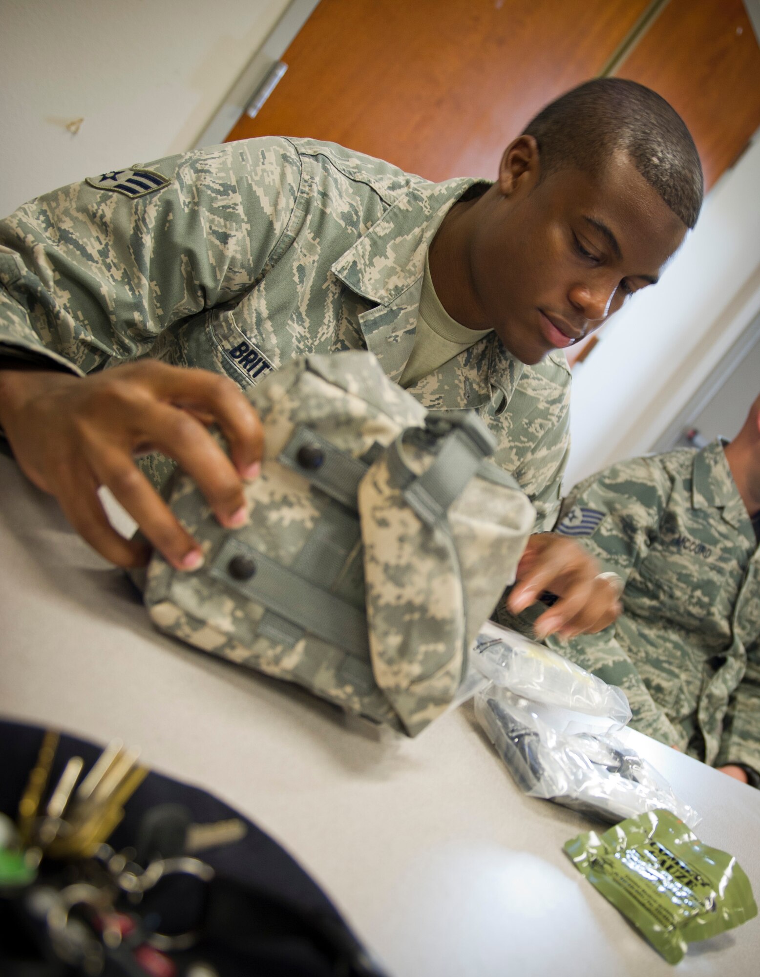 Senior Airman Donald Britt, 1st Special Operations Security Forces Squadron desk sergeant, looks at items in an Individual First-Aid Kit during a Self-Aid Buddy Care Hands-On course at the security forces squadron on Hurlburt Field, Fla., Jan. 22, 2015. Items in the IFAK can be used in life preserving situations, and include medical items such as emergency bandages, quick-clot, trauma shears and gauze. (U.S. Air Force photo/Senior Airman Krystal M. Garrett)