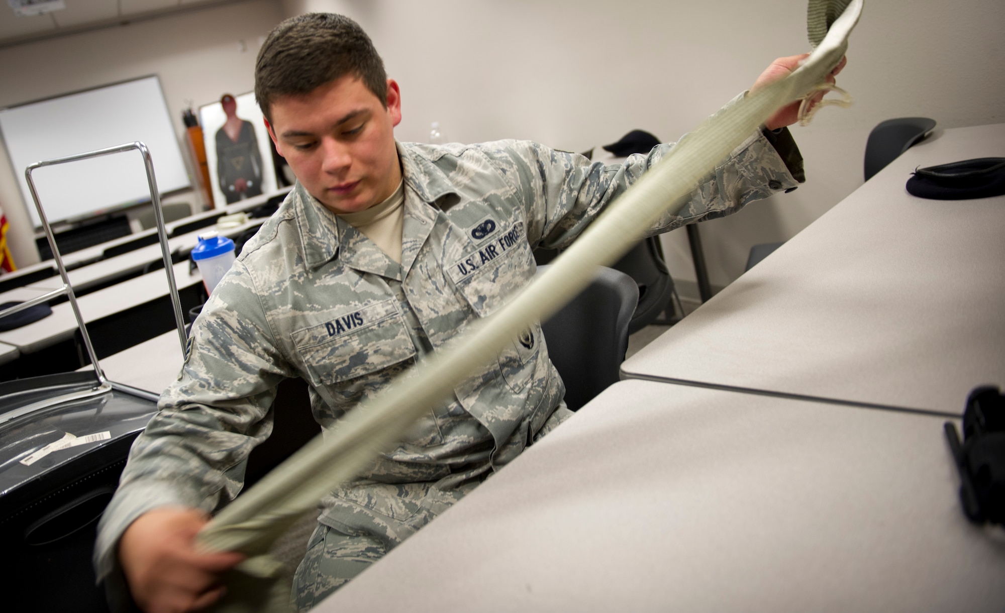 Senior Airman Martin Davis, 1st Special Operations Security Forces Squadron patrolman, unwraps an emergency bandage during a Self-Aid Buddy Care Hands-On course at the security forces squadron on Hurlburt Field, Fla., Jan. 22, 2015. Emergency bandages are used for bleeding injuries; they apply pressure to the wound, which, in turn stops the bleeding (U.S. Air Force photo/Senior Airman Krystal M. Garrett)