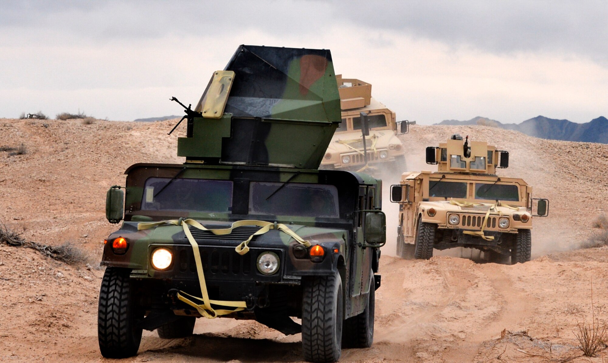 Security Forces Airmen attending the Base Security Operations course at the Silver Flag Alpha Range Complex north of Las Vegas drive HUMVEEs through desert terrain as they demonstrate skills to perform mounted and dismounted operations Dec. 17, 2014. This is the last BSO course that will take place at Silver Flag Alpha, as the 99th Ground Combat Training Squadron is projected to close in early 2015. All Air Force tactical security forces based training will be moved to the new Desert Defender Ground Combat Readiness Training Center at Fort Bliss, Texas. (U.S. Air Force photo by Tech. Sgt. Nadine Barclay/Released)
