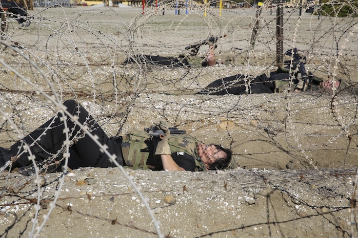 Department of Defense employees in the Executive Leadership Development Program navigate through concertina wire during the Bayonet Assault Course at Marine Corps Recruit Depot San Diego, Jan. 6.  The event was one of two physical training events the ELDP group performed at the depot to get a better understanding of what it takes to become a Marine.