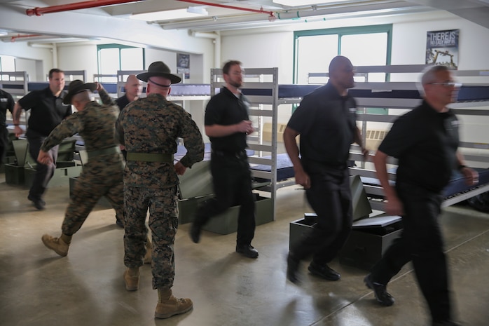 Drill instructors tell Department of Defense employees in the Executive Leadership Development Program to move with speed and intensity in a squad bay at Edson Range, Marine Corps Base Camp Pendleton, Calif., Jan. 6.  Drill instructors created a chaotic environment and expected the ELDP employees to accomplish their mission exactly as they expect it done by recruits.