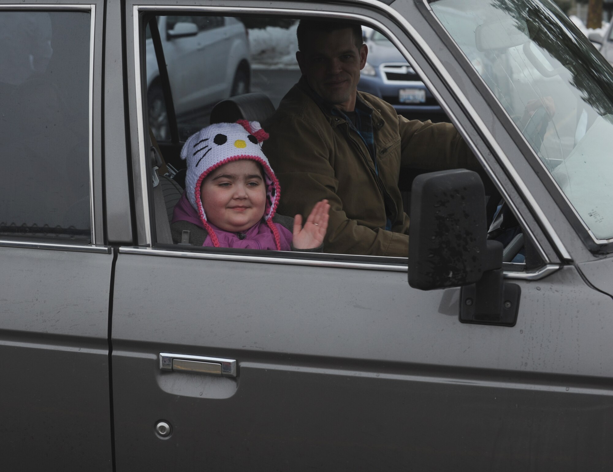 Tech. Sgt. Nick Bowater, 22nd Training Squadron Survival, Evasion, Resistance and Escape instructor, looks on as his daughter London waves to friends and classmates Jan. 16, 2015, at Fairchild Air Force Base, Wash. Hundreds of students, teachers and military family members lined up in support of London as she returned home from Seattle where she was receiving treatment. (U.S. Air Force photo/Staff Sgt. Samantha Krolikowski)