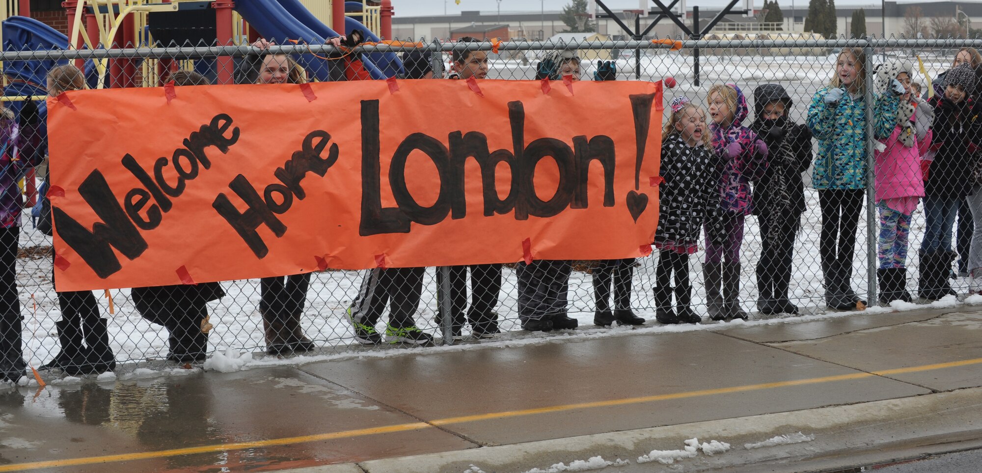 Students from Michael Anderson Elementary school line up along the playground fence Jan. 16, 2015, at Fairchild Air Force Base, Wash. More than 100 students, friends and military families showed their support for London Bowater, a second grader diagnosed with acute lymphoblastic leukemia, as she returned from Seattle where she was receiving treatment. Bowater is in remission after her treatment. (U.S. Air Force photo/Staff Sgt. Samantha Krolikowski)