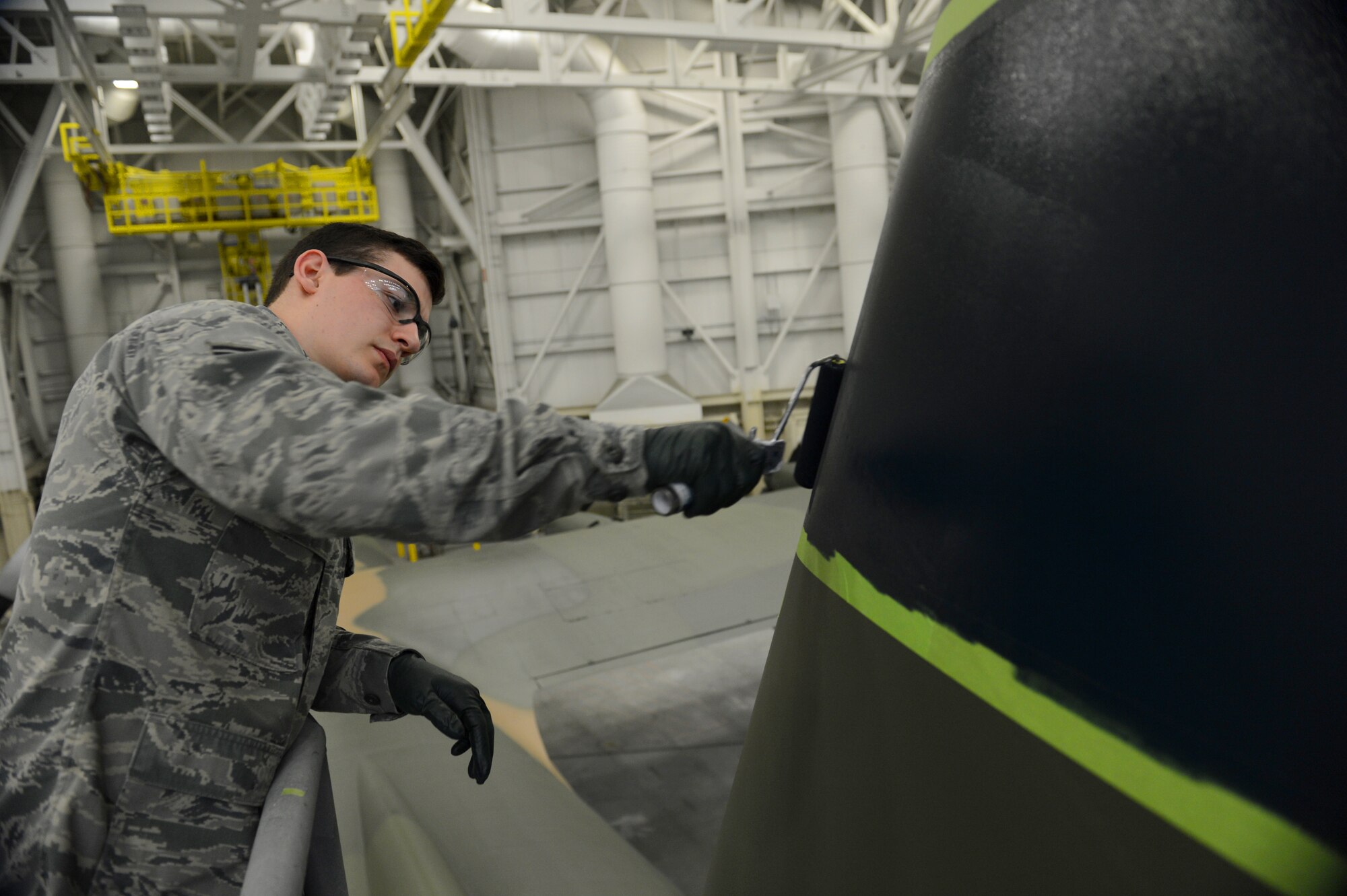 Senior Airman Justin Lounder, 62nd Maintenance Squadron aircraft structural maintenance technician, paints a part of a C-130 Hercules Jan. 13, 2015, during the repainting of the aircraft at Joint Base Lewis-McChord, Wash. Airmen from the 62nd MXS spent more than two months repainting a C-130 Hercules in Vietnam era camouflage scheme.  The aircraft was painted for the McChord Air Museum. (U.S. Air Force photo/Airman 1st Class Keoni Chavarria)