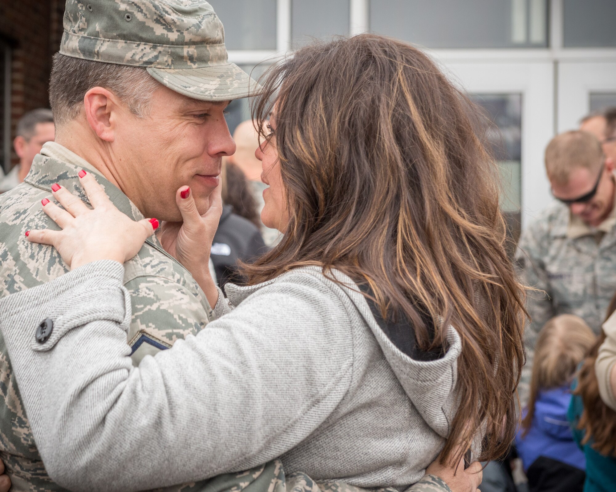 Master Sgt. Darren Wilson, 934th Operations Support Squadron, embraces his family as he returns from overseas.  Members of the 934th Airlift Wing, friends, and family welcomed home their Airmen as they return back from deployment overseas to the Minneapolis-St. Paul Air Reserve Station, Minn., Jan. 20.  (U.S. Air Force photo by Shannon McKay/Released)