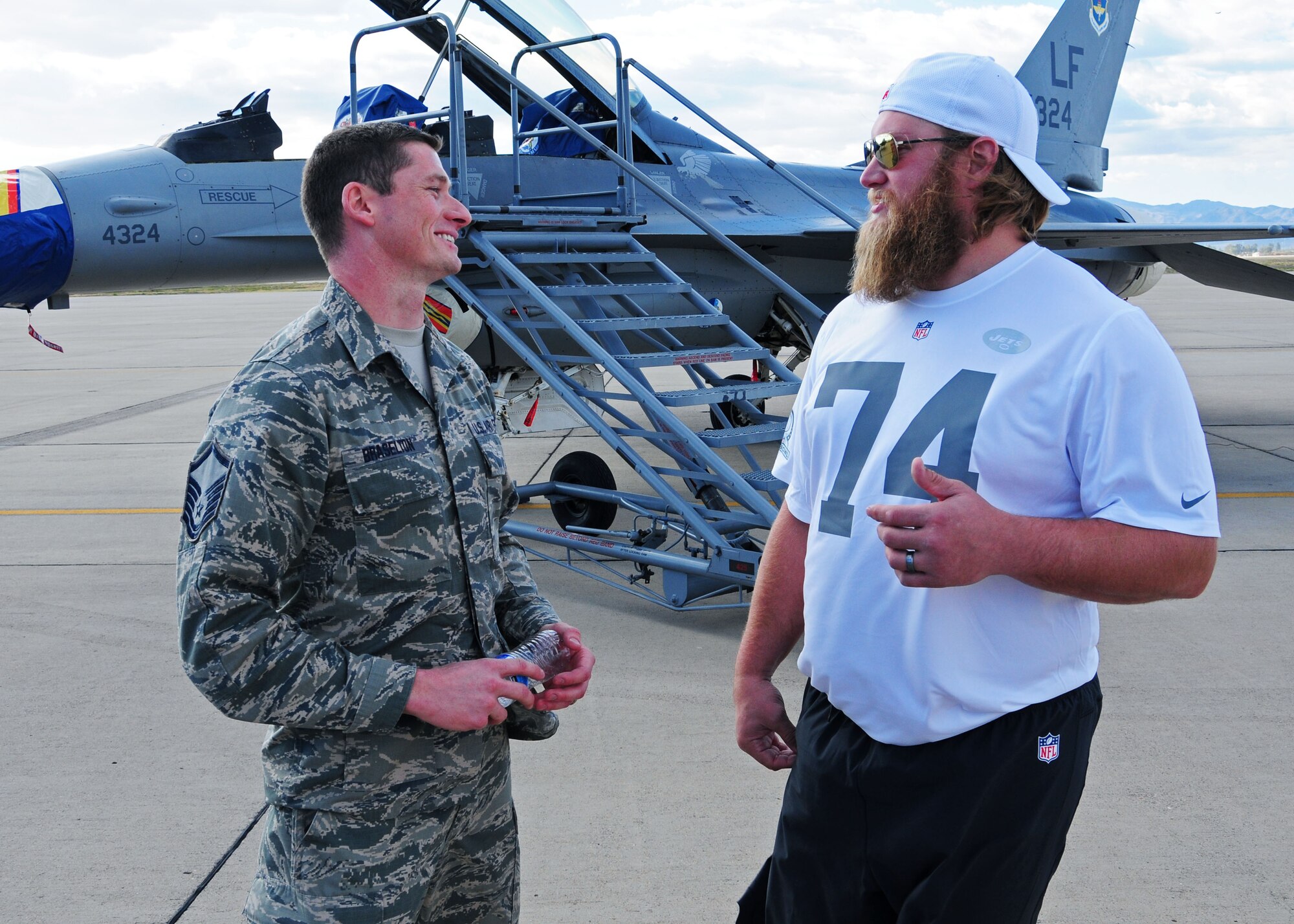 Master Sgt. Jeffrey Braselton, 944th Fighter Wing personnel systems management chief, talks with Nick Mangold, National Football League New York Jets offensive lineman, Jan 21 while NFL Pro Bowl players visit Luke Air Force Base, Ariz. (U.S. Air Force photo by Tech. Sgt. Louis Vega Jr.)