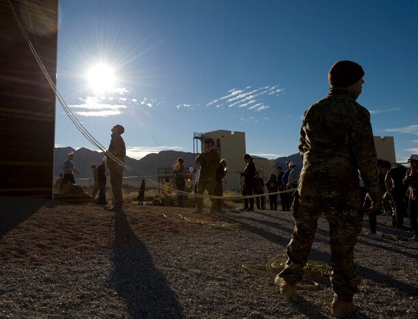Members of the 58th Rescue Squadron secure the rappelling line for Army Junior Reserve Officer Training Corps cadets as they descend the rappelling tower at Nellis Air Force Base, Nev., Jan. 23, 2015. Three Army JROTC units toured Nellis AFB to expand their knowledge about the Air Force, the various career fields and to get familiar with the base. (U.S. Air Force photo by Airman 1st Class Mikaley Towle)