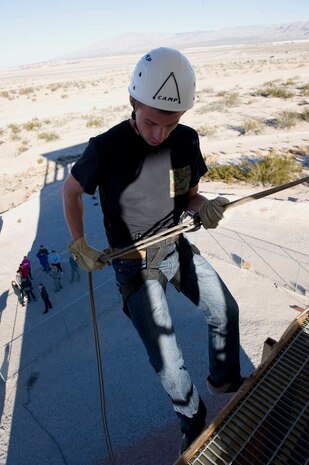 An Army Junior Reserve Officer Training Corps cadet prepares to descend down the rappelling wall at Nellis Air Force Base, Nev., Jan. 23, 2015. Three Army JROTC units visited the Thunderbirds museum, the Threat Training Facility, and had lunch at the Crosswinds Dining Facility during their tour of the base. (U.S. Air Force photo by Airman 1st Class Mikaley Towle)  