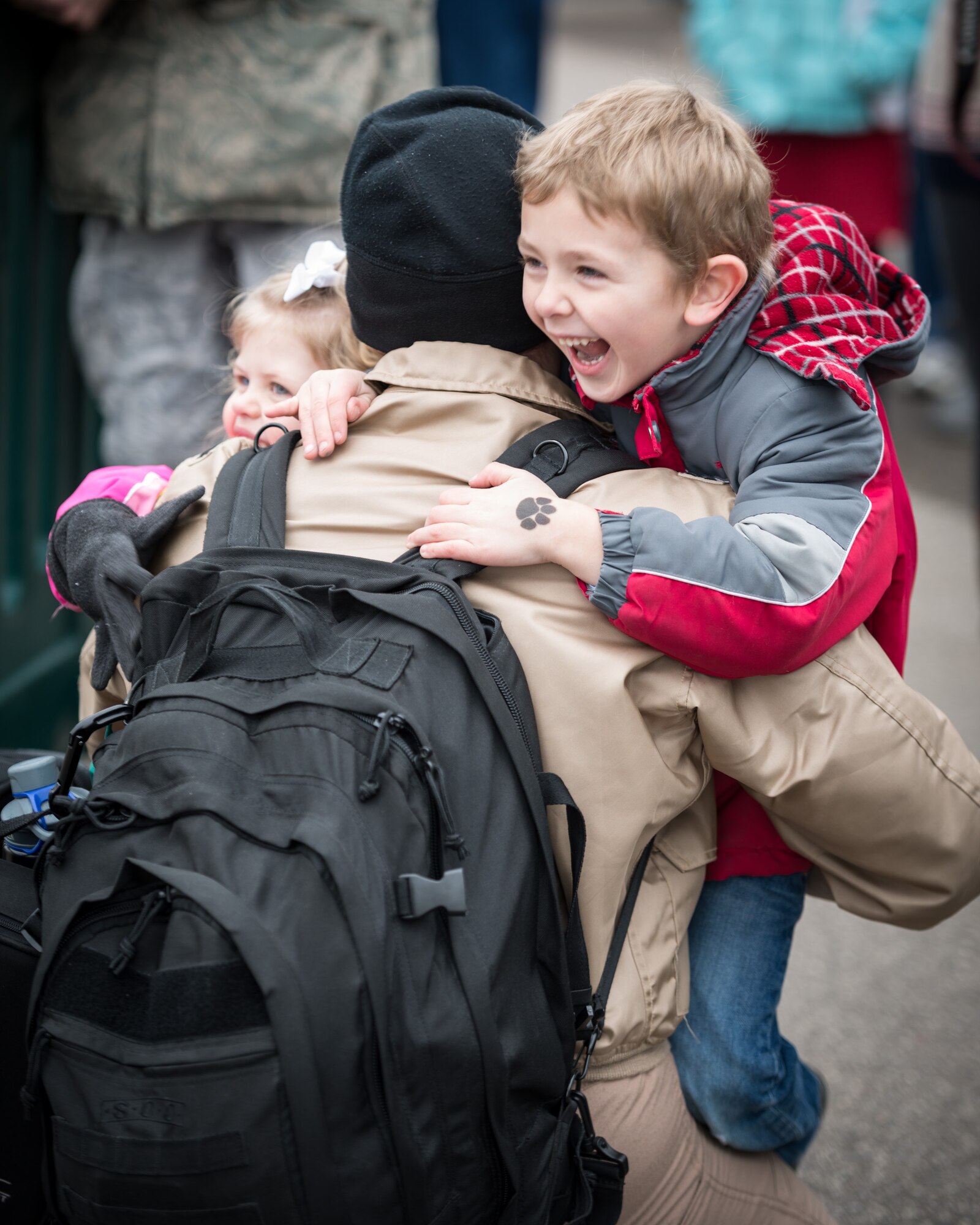 Captain Lee Place, 934th Operations Support Squadron, greets his overjoyed children as he exits the aircraft.  Members of the 934th Airlift Wing, friends, and family welcomed home their Airmen as they returned back from deployment overseas to the Minneapolis-St. Paul Air Reserve Station, Minn., Jan. 20.  (U.S. Air Force photo by Shannon McKay/Released)