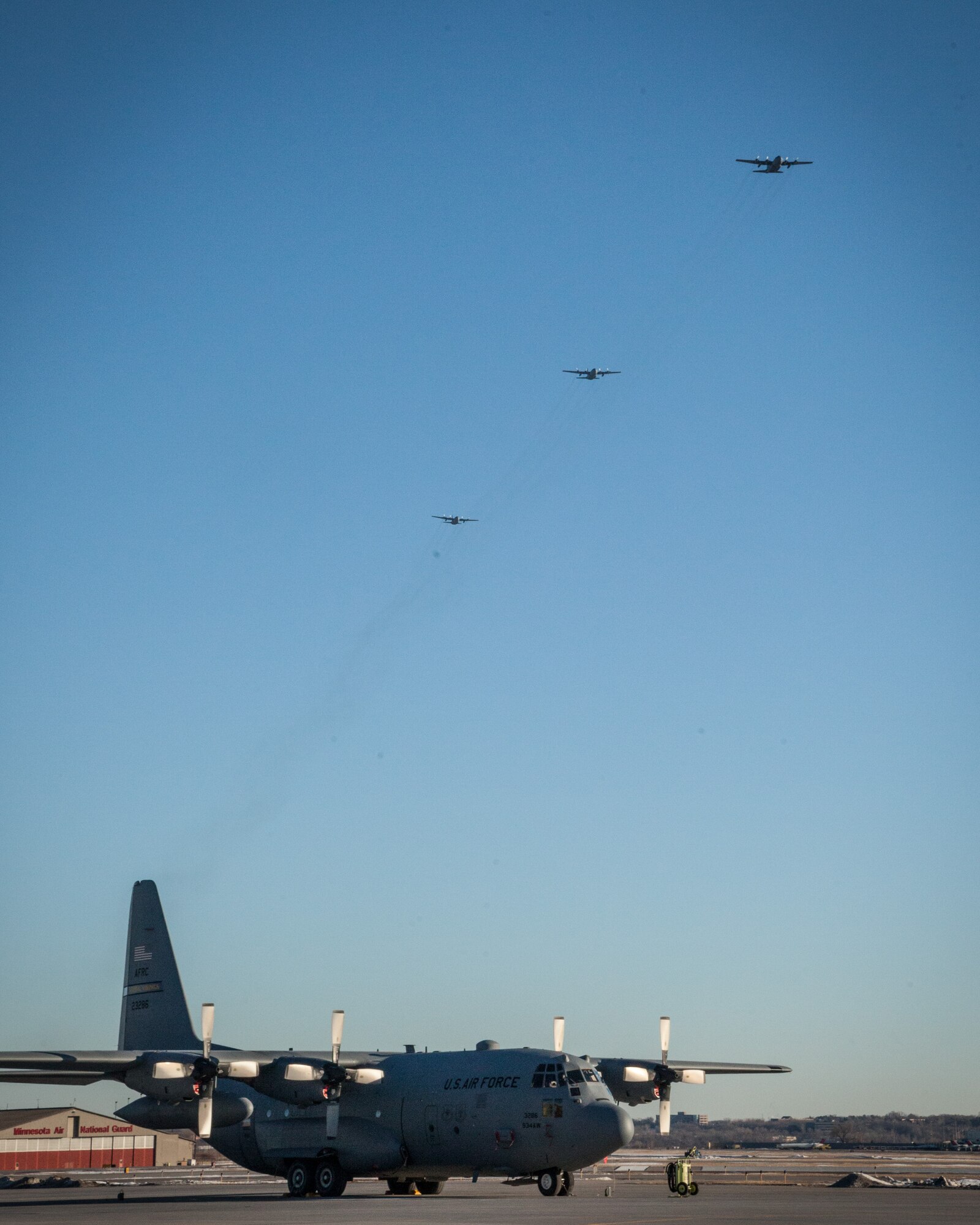 Returning 934th Airlift Wing aircraft approach in formation as friends and family watch and wait to welcome their Airmen home as they return from deployment to the Minneapolis-St. Paul Air Reserve Station, Minn., Jan. 18.  (U.S. Air Force photo by Shannon McKay/Released)