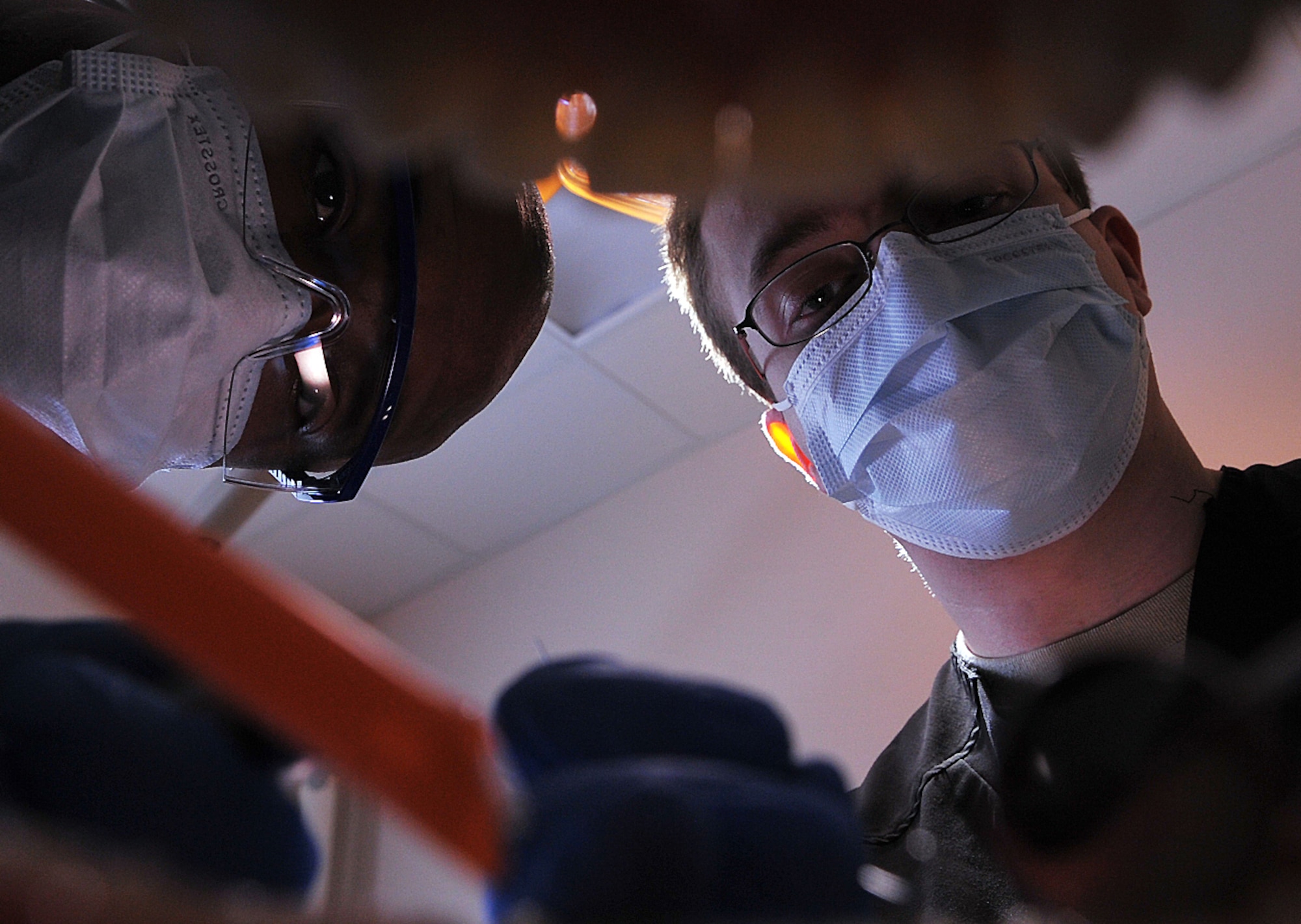 Capt. (Dr.) Kevin Kemarly, 319th Medical Operations Squadron deputy flight commander of the dental flight, and Senior Airman Reese, dental assistant, practice examining teeth with a hygiene mouth and brush model at Grand Forks Air Force Base, N.D. Jan. 14, 2015. Kemarly was selected as the 2014 Air Mobility Command Clinical Dentist of the Year. (U.S. Air Force photo/Airman 1st Class Bonnie Grantham)