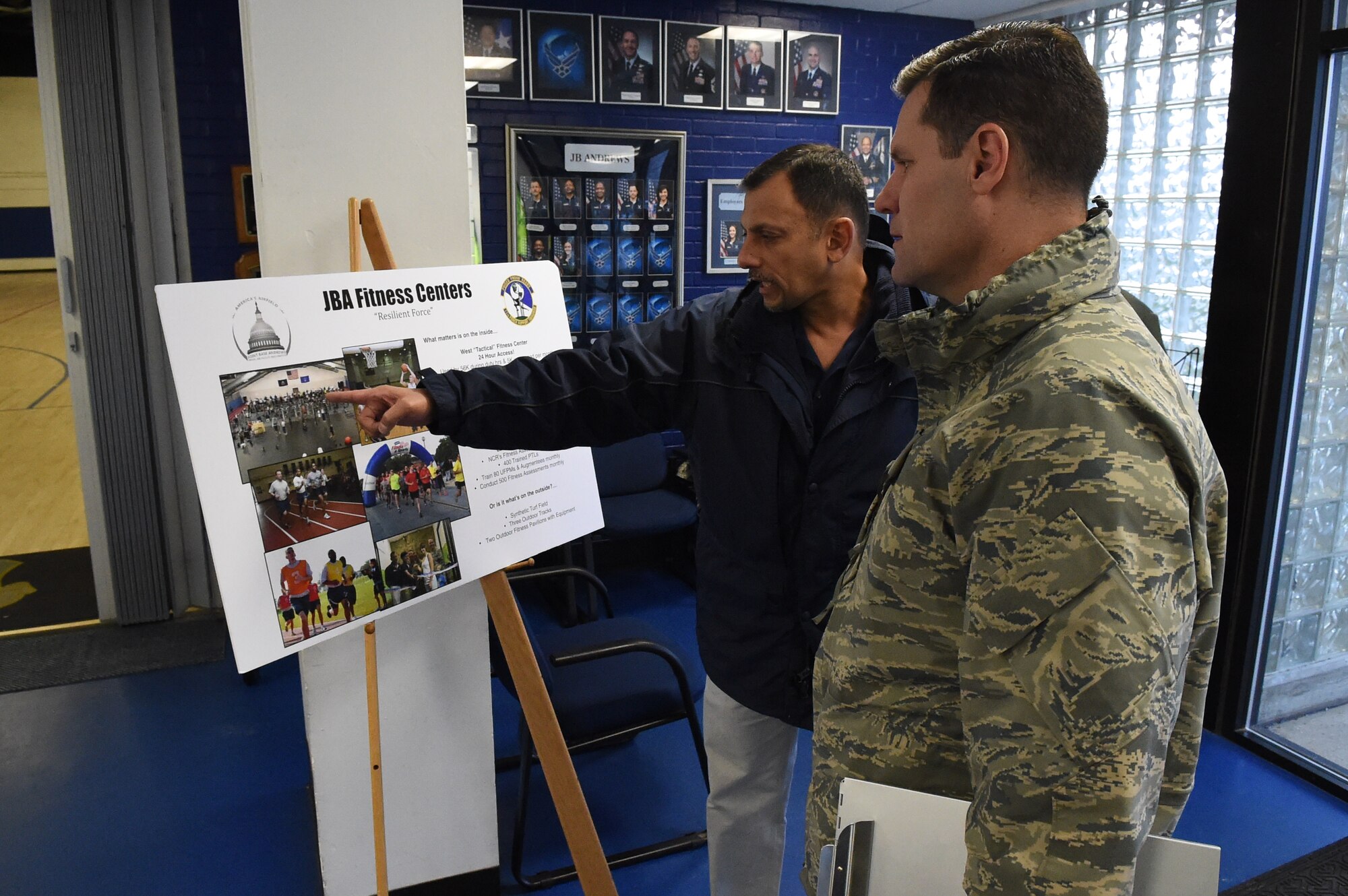 Mr. Isaac Melendez, Fitness Center director, shows Col. John Devillier, 88th Air Base Wing commander, is shown the features and activities hosted by the West Fitness Center on Joint Base Andrews, Md., Jan. 13, 2015. (U.S. Air Force photo/Airman 1st Class Joshua R. M. Dewberry)