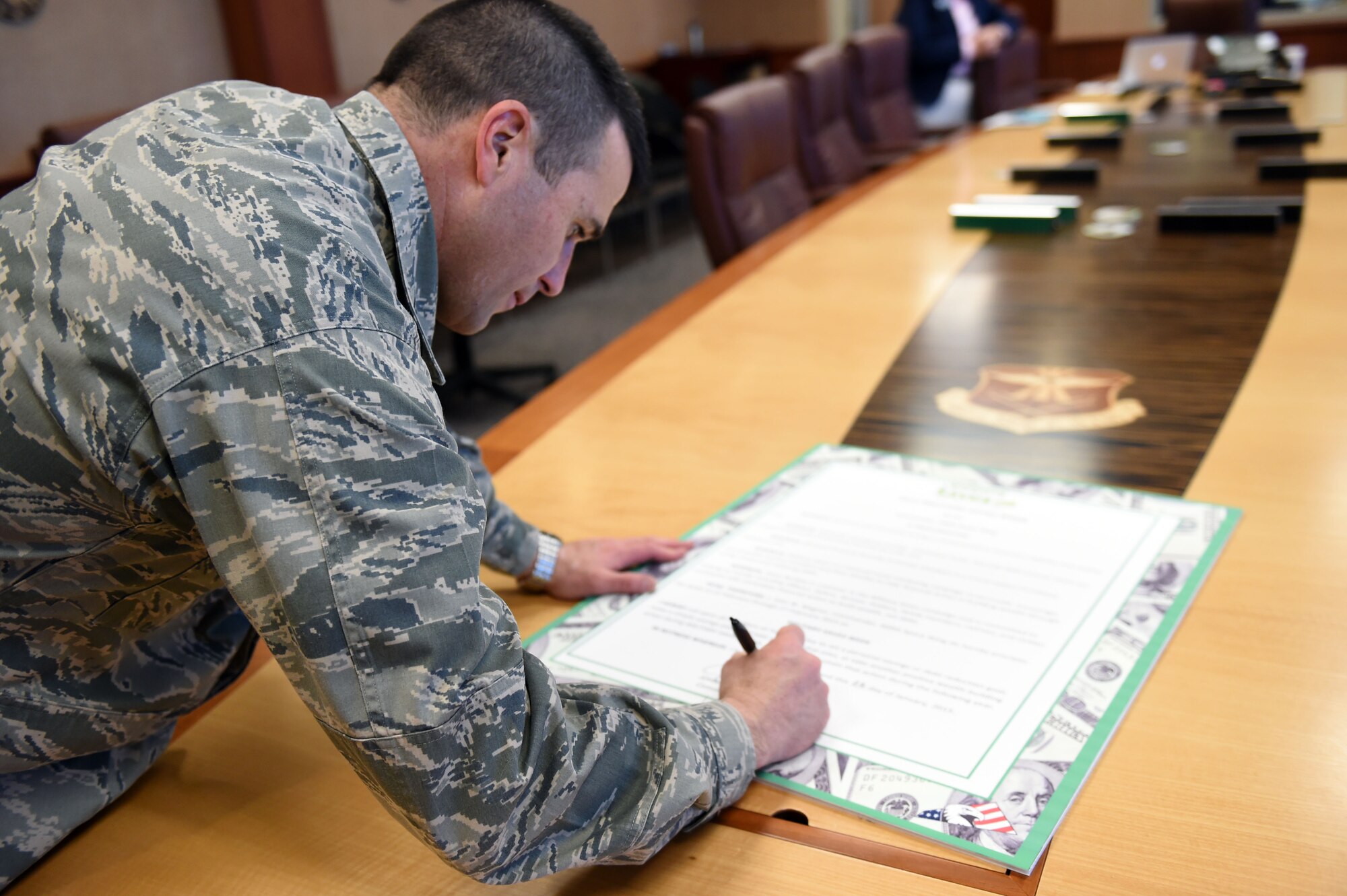 Col. John Wagner, 460th Space Wing commander, signs the pledge declaring the week of February 23-27 be Military Saves Week Jan. 22, 2015, in the SW conference room on Buckley Air Force Base, Colo. Military Saves Week is an annual opportunity for service members and their families to learn about smart financing. (U.S. Air Force photo by Airman 1st Class Emily E. Amyotte/Released)