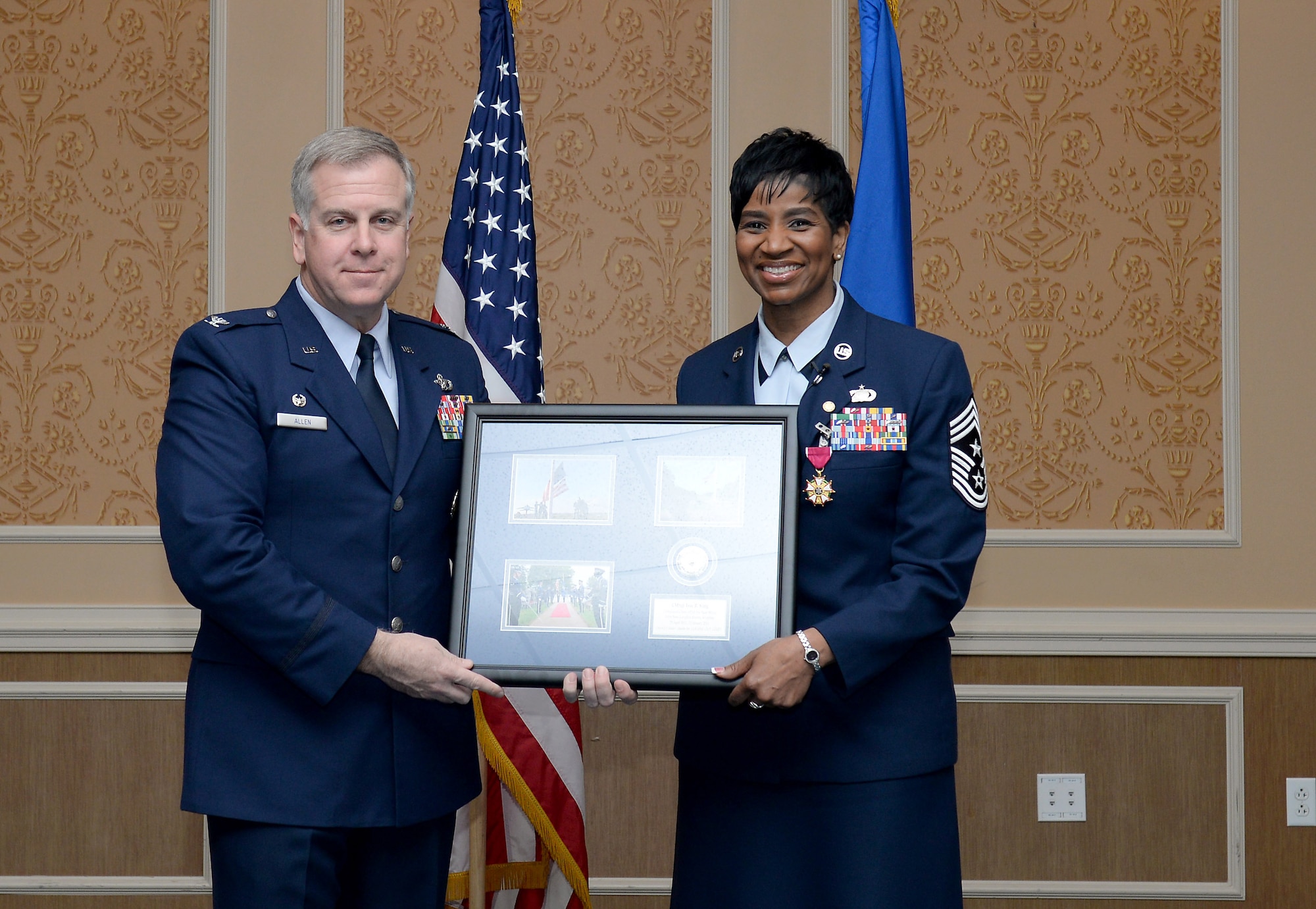 U.S. Air Force Col. John J. Allen Jr., 633rd Air Base Wing commander, presents Chief Master Sgt. Trae King, 633 ABW command chief, with a collage during her retirement ceremony at Langley Air Force Base, Va., Jan. 23, 2015. King is known for her ‘Lead-Out-Loud’ style of leadership which highlights the importance of the five “R”s; being ready, resilient, reliable, relevant and resourceful. (U.S. Air Force photo by Staff Sgt. Antoinette Gibson/Released) 