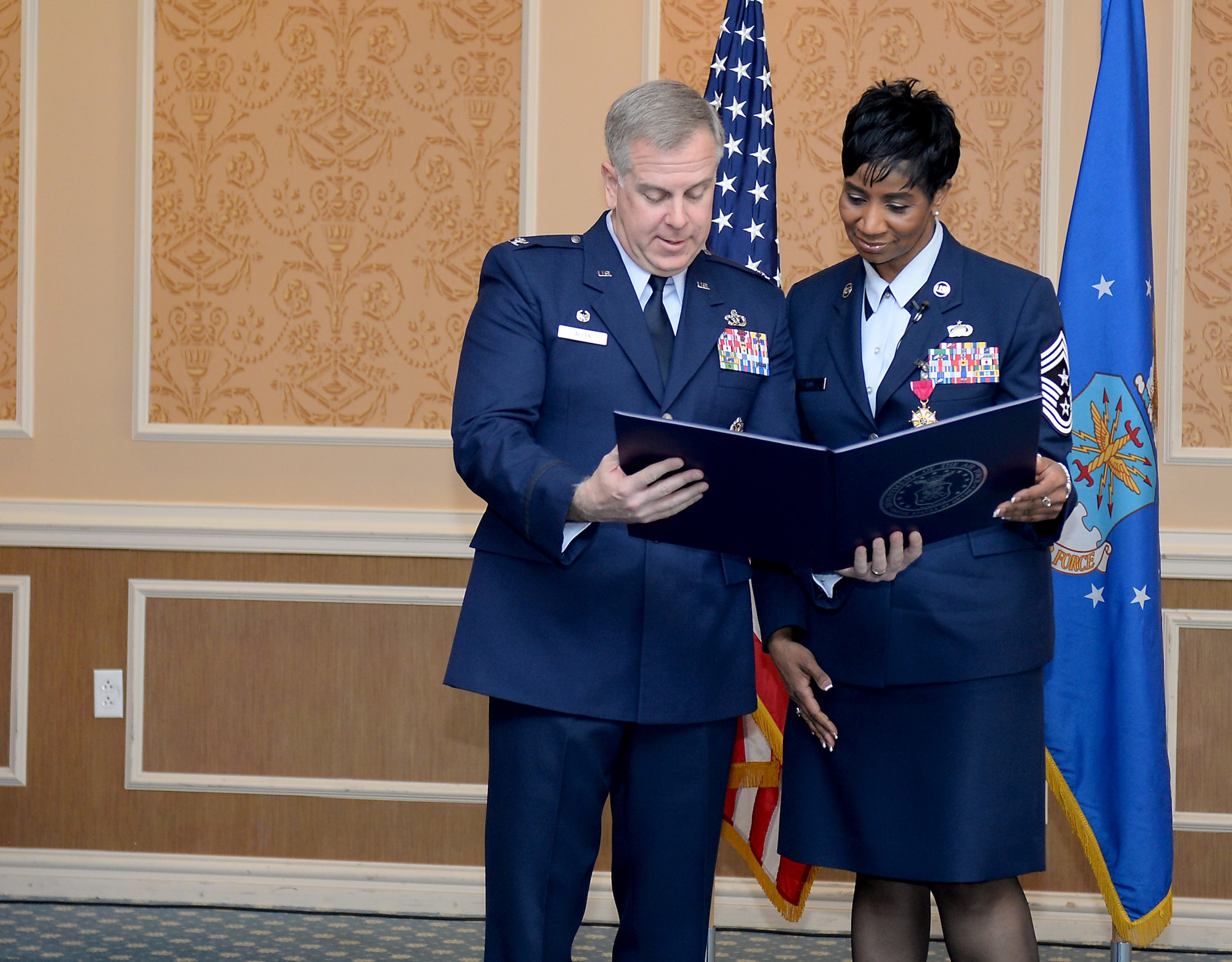 U.S. Air Force Col. John J. Allen Jr., 633rd Air Base Wing commander, presents Chief Master Sgt. Trae King, 633 ABW command chief, a letter from President Barack Obama during her retirement ceremony at Langley Air Force Base, Va., Jan. 23, 2015. During her 3-year tour at Langley, King advised two commanders and mentored more than 6,000 Service members. (U.S. Air Force photo by Staff Sgt. Antoinette Gibson/Released)