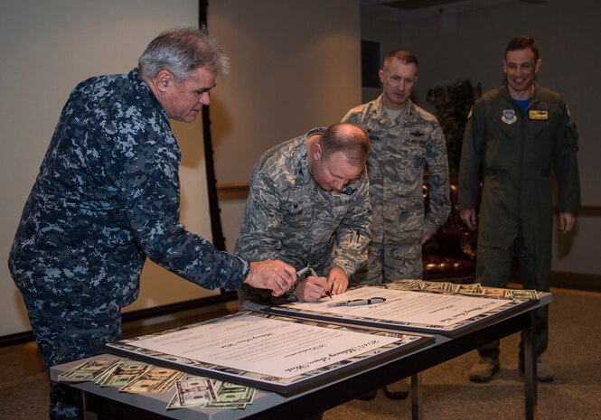 Col. Jeffrey DeVore, Joint Base Charleston commander, Capt. Timothy Sparks, JB Charleston deputy commander, Col. John Lamontagne, 437th Airlift Wing commander, and Col. James J. Fontanella, 315th Airlift Wing commander, sign the Military Saves Week proclamation letter Jan. 23, 2015, at the JB Charleston Education Center auditorium. Military Saves, a component of America Saves and a partner in the DoD Financial Readiness Campaign, is a research-based social marketing campaign intended to motivate, support, and encourage military families to save money and build wealth. (U.S. Air Force photo/ Senior Airman Dennis Sloan)