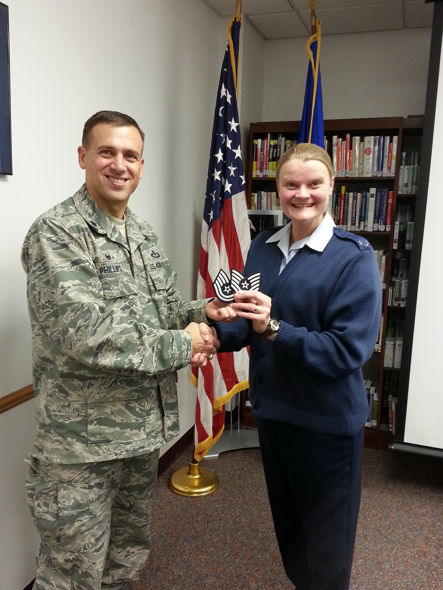 Lt. Col. Steven Phillips, 343rd Recruiting Squadron commander, presents newly promoted Tech. Sgt. Joanne Moseley with her stripes at Offutt Air Force Base, Neb., Dec. 22. Moseley was promoted under the Stripes for Exceptional Performers Program.  (U.S. Air Force photo)