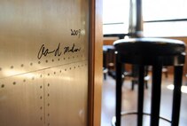 The corner of the bar signed by the U.S. Air Force Maj. Aaron D. Madison the carpenter that created the central piece of the 338th Combat Training Squadron’s heritage room Jan. 20, Offutt Air Force Base, Neb.  Heritage rooms are a combined self-help effort made by the men and women of that flying squadron.  (U.S. Air Force photo by Josh Plueger/Released)
