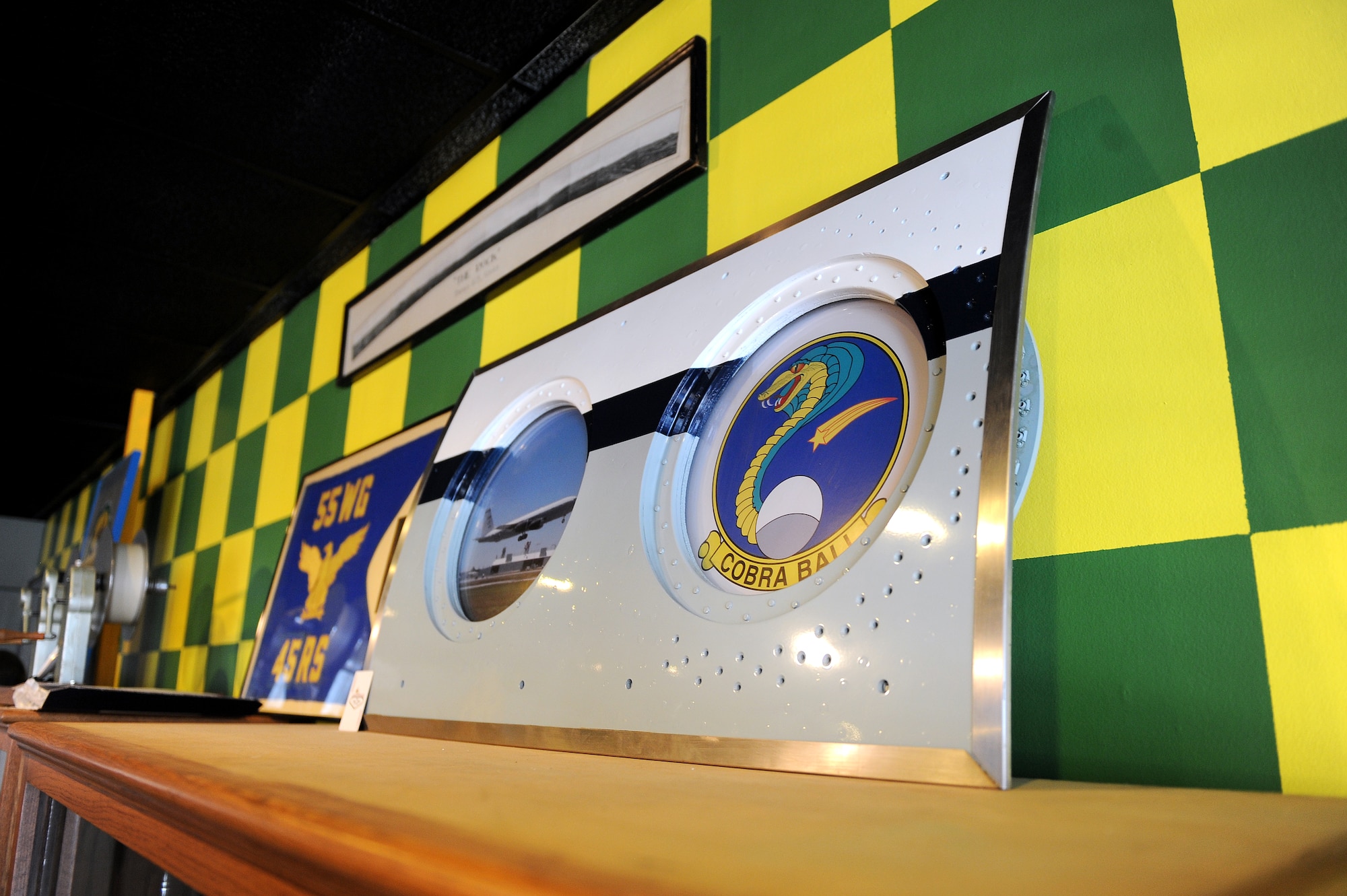 A portion of a RC-135 fuselage made into a picture frame sits atop of a large display case inside of the 45th Reconnaissance Squadron’s heritage room on Jan. 14, Offutt Air Force Base, Neb.  The heritage room is a common meeting place where airman can convene.  (U.S. Air Force photo by Josh Plueger/Released)