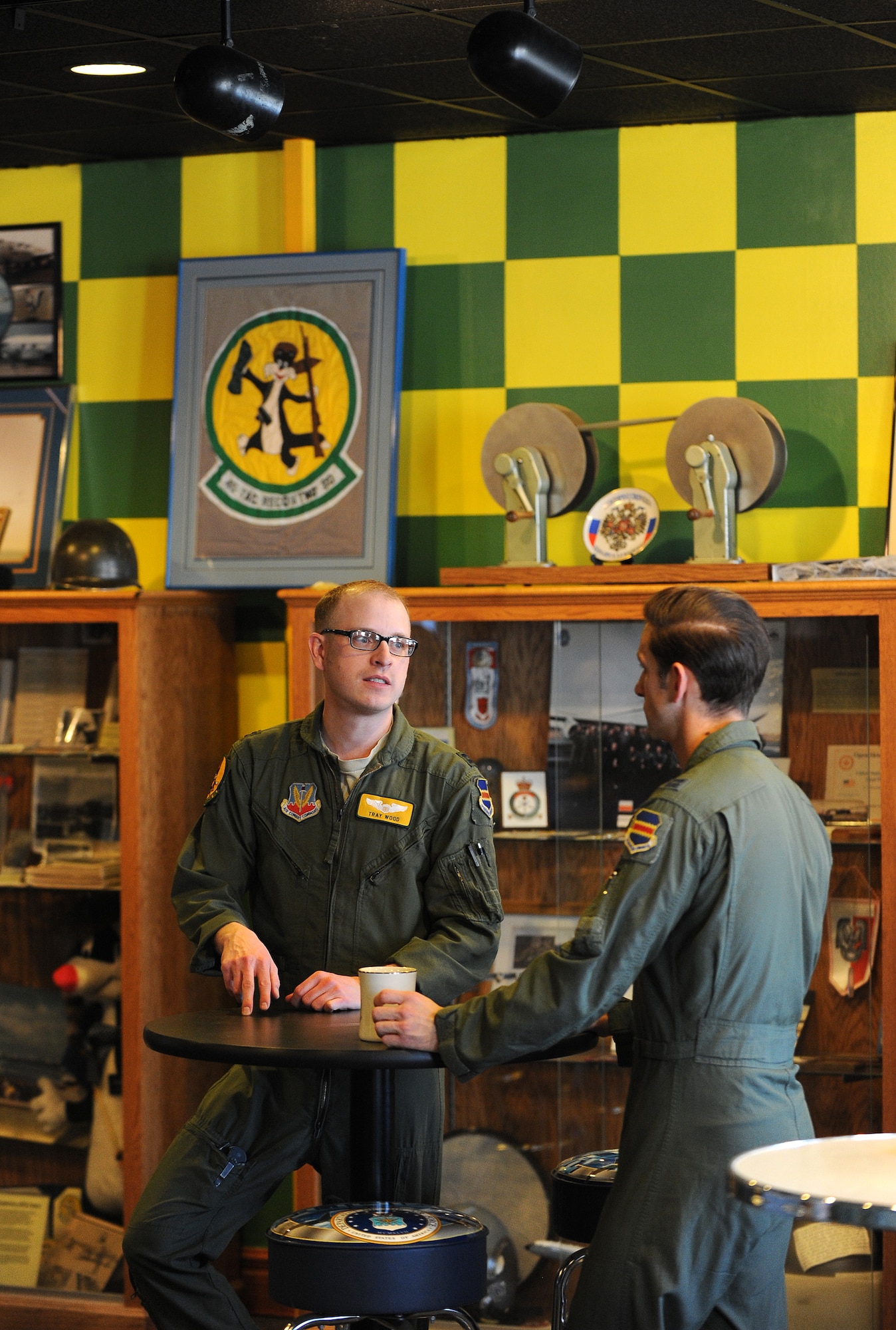 U.S. Air Force Capt. Tray Wood talks with U.S. Air Force Capt. Joshua Eldridge, both 45th Reconnaissance Squadron members, talk in their heritage room on Jan. 14, Offutt Air Force Base, Neb.  Heritage rooms are used in numerous ways to include roll call ceremonies to a break room to have lunch.  (U.S. Air Force photo by Josh Plueger/Released)