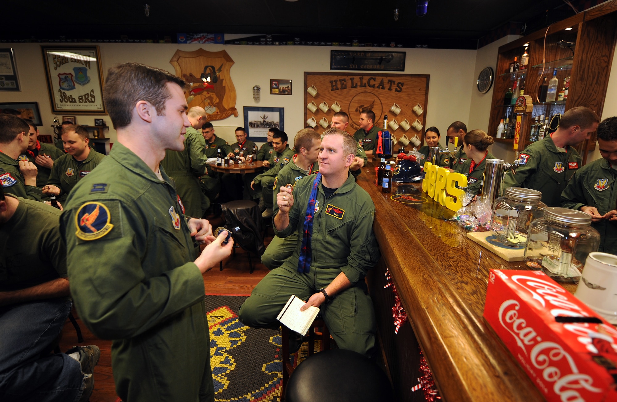 U.S. Air Force Lt. Col. Lisle Babcock, 38th Reconnaissance Squadron commander, pulls his squadron challenge coin during a roll call meeting held in the 38th RS heritage Room on Jan. 9, Offutt Air Force Base, Neb.  Challenge coins have been an aviator tradition going back as far as World War I.  (U.S. Air Force photo by Josh Plueger/Released)