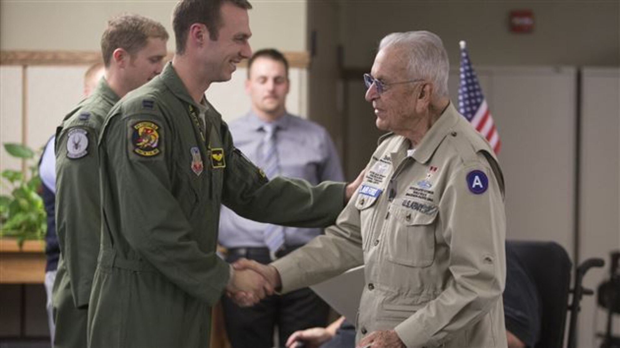 Fighter pilot Captain Tim "Check" Six shakes the hand of Bob Ramos at the George E. Wahlen Veterans Home in Odgen. Capt. Six and Capt. Brad "Scooby" Hunt spoke to veterans about their experiences as 388th Fighter Wing pilots recently. (Courtesy photo)