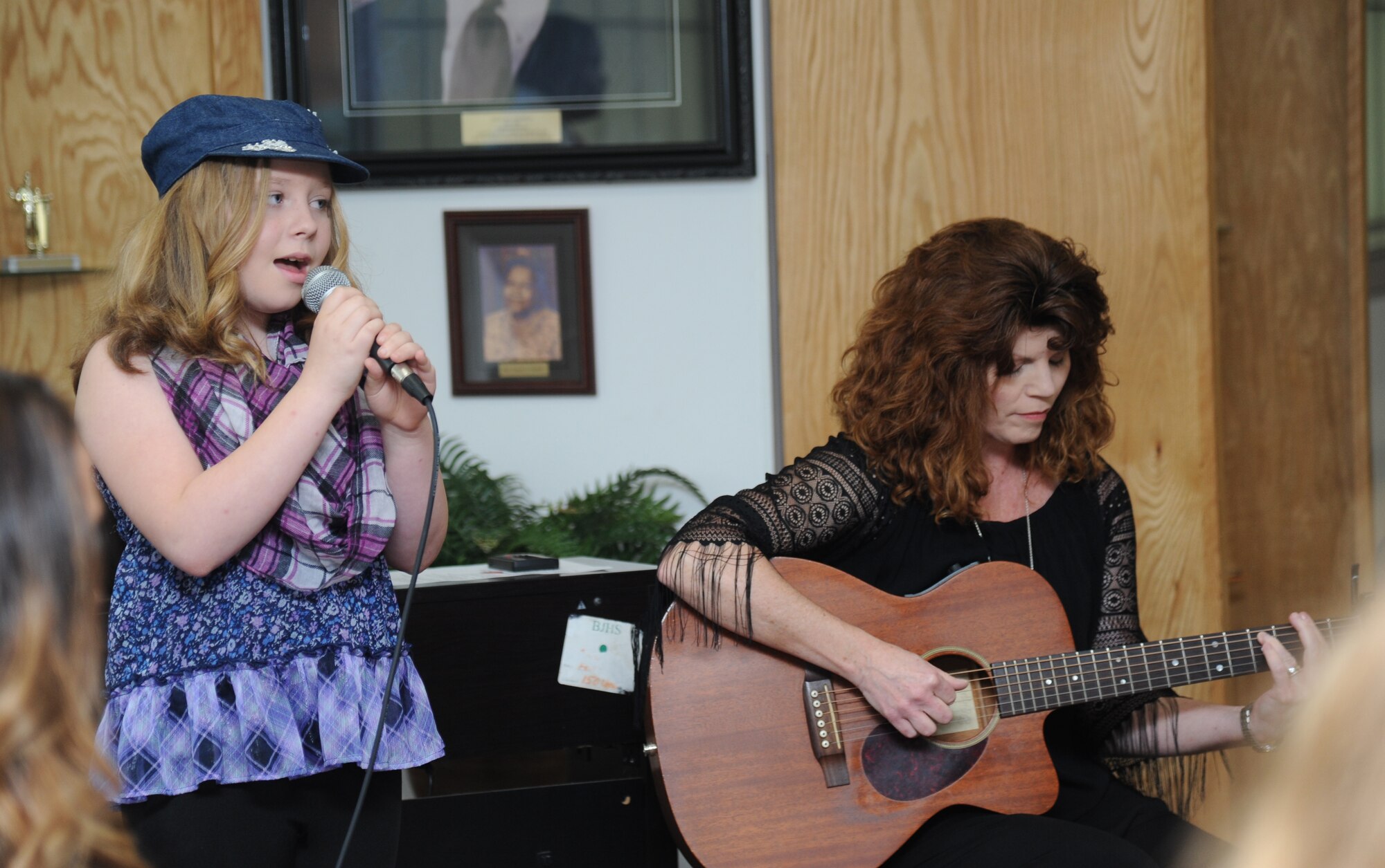The daughter of Maj. Carla Gleason, 81st Training Wing public affairs chief, sings “Put Your Record On” as Marsha Gaines, Jeff Davis Elementary School music teacher, plays guitar during a Biloxi Public School Board meeting Jan. 20, 2015, at the Dukate Building, Biloxi, Miss. The meeting was hosted by Jeff Davis Elementary School who selected talented children to perform for the board, which meets monthly. (U.S. Air Force photo by Kemberly Groue)