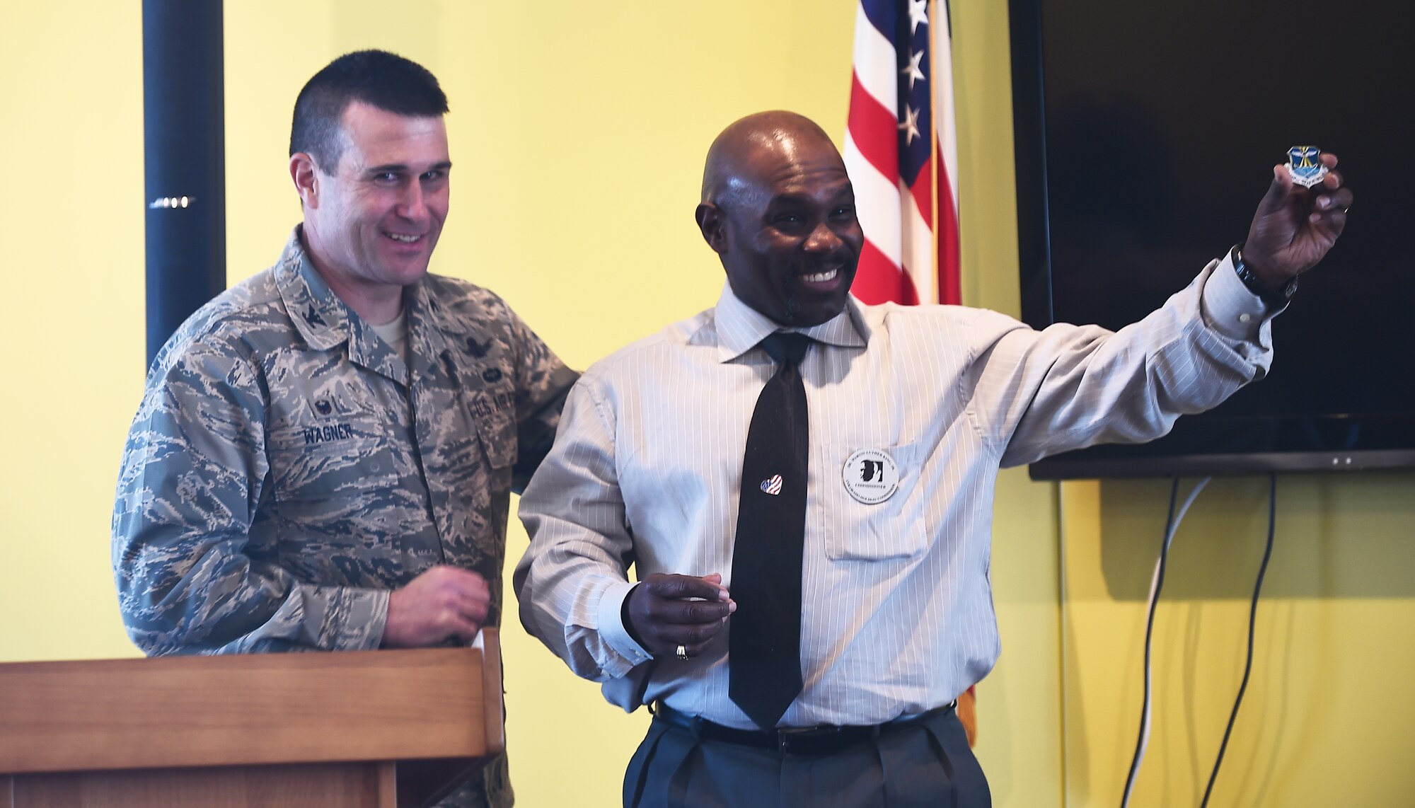 Vern L. Howard, Martin Luther King Colorado Holiday Commission chairman, spoke Jan. 22, 2015c at the Panther Den on Buckley AFB, Colo., to commemorate Dr. Martin Luther King Jr. Howard was given a 460th Space Wing coin by Col. John W. Wagner, 460th SW commander, to show appreciation for Howard’s lecture on Dr. Martin Luther King Jr. (U.S. Air Force photo by Airman 1st Class Luke Nowakowski/Released)