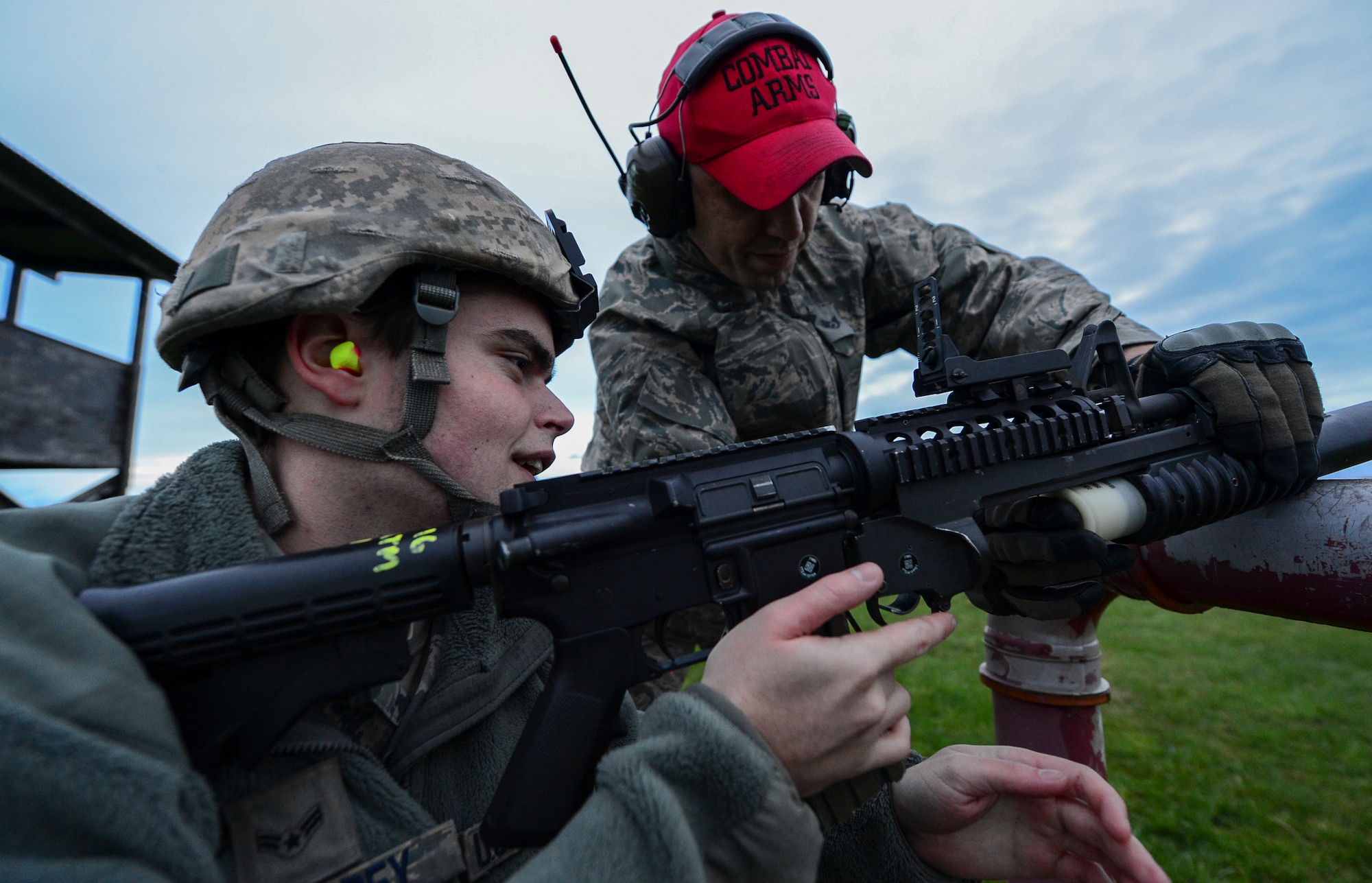 Staff Sgt. Alan Daly, 48th Security Forces Squadron combat arms instructor, gives range correction instructions to Airman 1st Class Brennan Eisenbrey, 48th SFS response force member, during an M203 grenade launcher qualification course at Royal Air Force Feltwell, England, Dec. 12, 2014. Combat Arms Training and Maintenance instructors ensured the safe and effective operation of weapon systems. (U.S. Air Force photo by Airman 1st Class Erin R. Babis/Released)