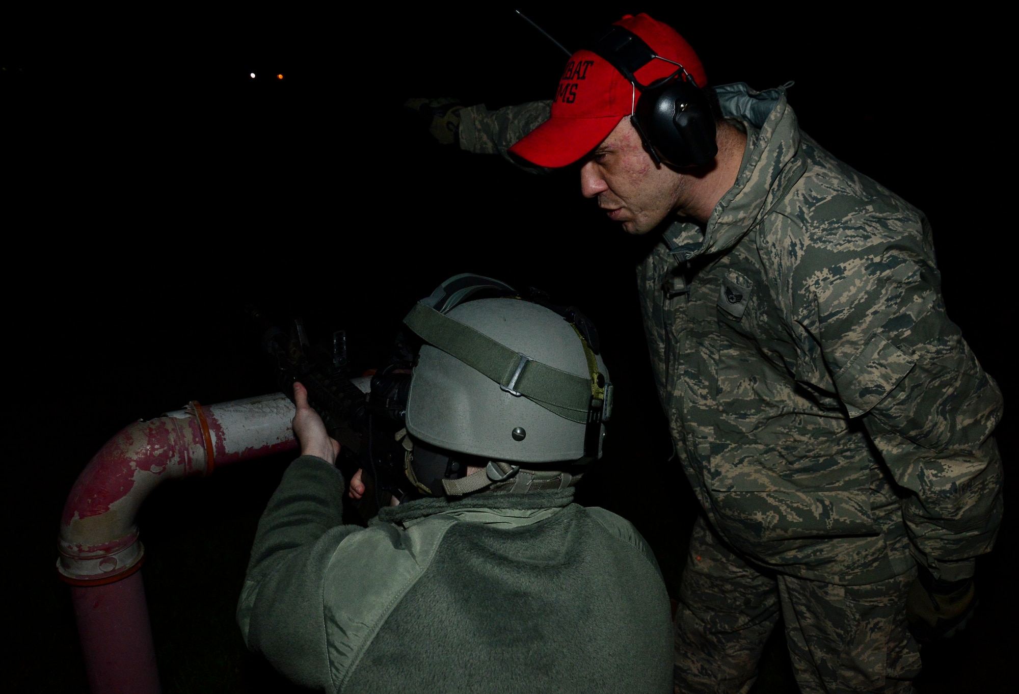 Staff Sgt. Alan Daly, 48th Security Forces Squadron combat arms instructor, instructs Airman 1st Class Brennan Eisenbrey, 48th SFS response force member, on the selection of targets during an M203 grenade launcher qualification course night fire portion at Royal Air Force Feltwell, England, Dec. 12, 2014. Combat Arms Training and Maintenance instructors ensured the safe and effective operation of weapon systems. (U.S. Air Force photo by Airman 1st Class Erin R. Babis/Released)
