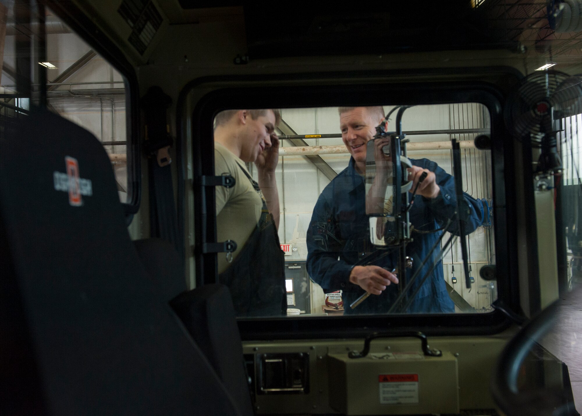 Col. Michael Grismer, 436th Airlift Wing commander, and Staff Sgt. Erik Struss, 436th Logistics Readiness Squadron vehicle maintenance, chat while working on an Oshkosh snow plow Jan. 22, 2015, in the heavy vehicle maintenance shop on Dover Air Force Base, Del. Grismer spent an hour working with the Airmen. (U.S. Air Force photo/Airman 1st Class Zachary Cacicia)