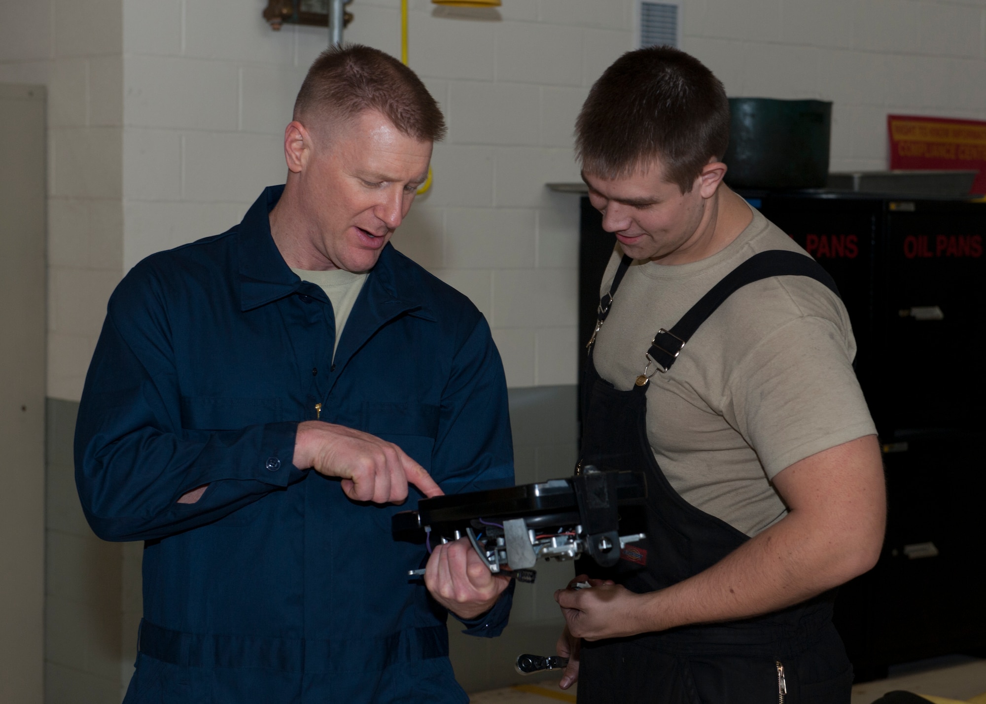 Col. Michael Grismer, 436th Airlift Wing commander, examines a side-view mirror with Staff Sgt. Erik Struss, 436th Logistics Readiness Squadron vehicle maintenance, Jan. 22, 2015, in the heavy vehicle maintenance shop on Dover Air Force Base, Del. The newly created Commander to Work program has Grismer going around base to work with Airmen under his command. (U.S. Air Force photo/Airman 1st Class Zachary Cacicia)