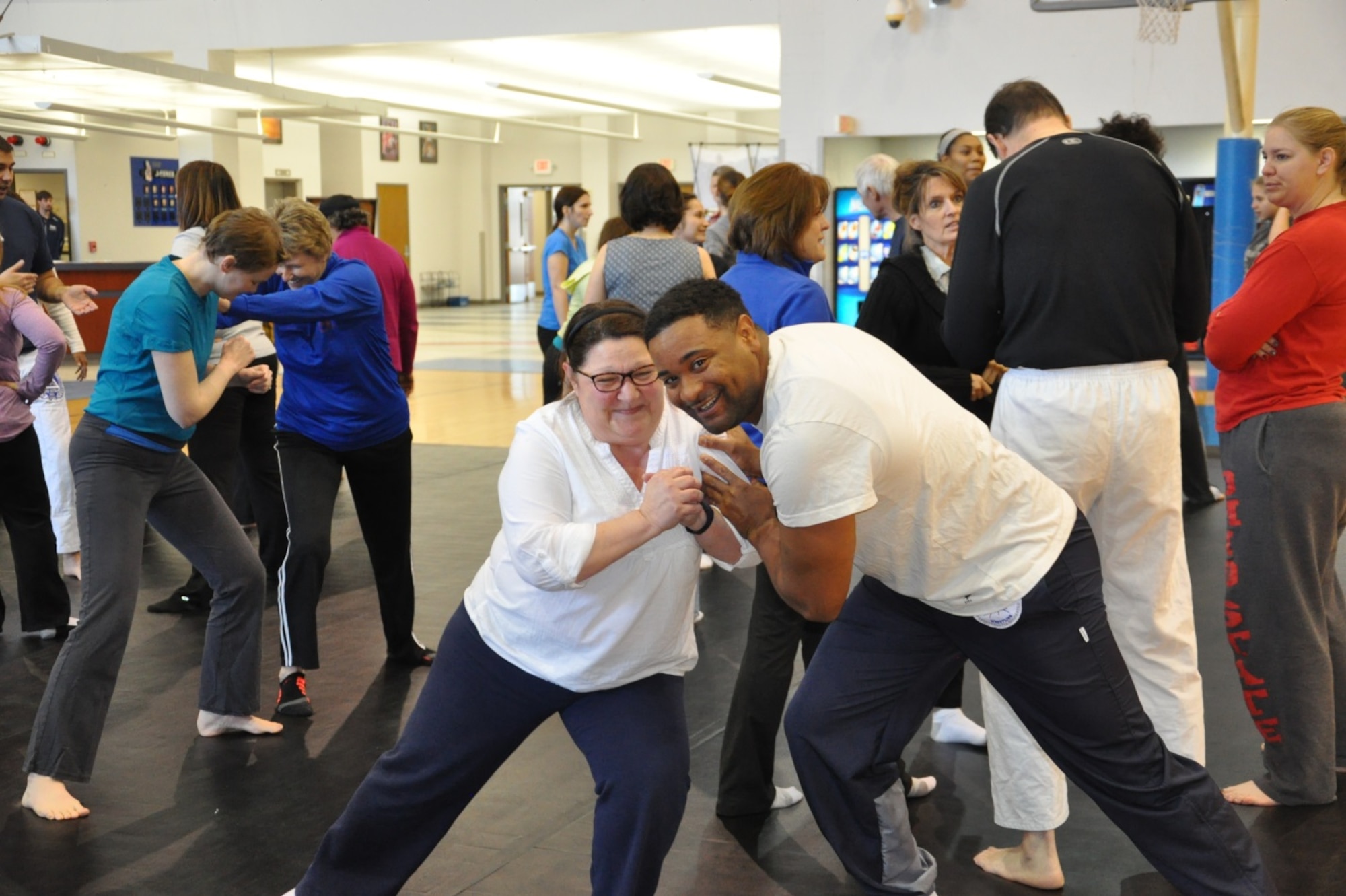 During the Gracie Defense Systems' two-hour seminar on Jan. 13, at the Wright Field Fitness Center, Staff Sgt. Brandon Davis and Rose Tobin practice the technique of bracing themselves with one leg extended for balance and control when someone tries to push you down. (Air Force photo by Kimberly Gaither)