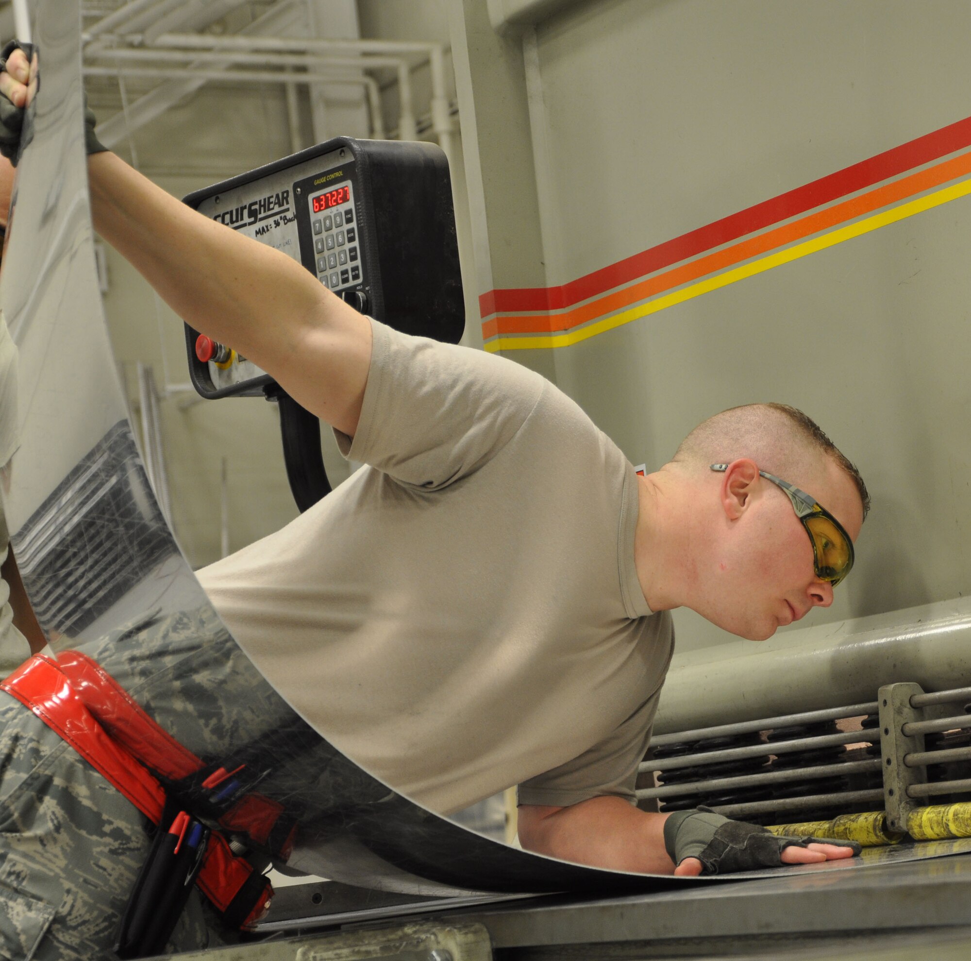 Tech. Sgt. Devin Street, 931st Maintenance Squadron Air Reserve Technician, runs a piece of sheet metal through a slicer at McConnell Air Force Base, Kan., Jan. 22, 2015. Street, who works in the Aircraft Structural Maintenance Shop, is helping upgrade the galleys used in the KC-135 Stratotankers. (U.S. Air Force photo by Tech. Sgt. Abigail Klein)