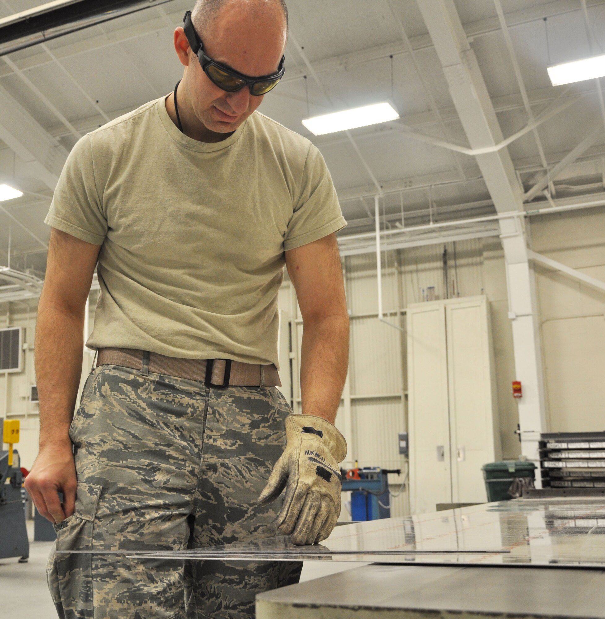 Tech. Sgt. John Barker, 931st Maintenance Squadron Air Reserve Technician, carefully measures a piece of sheet metal before running it through a metal slicer at McConnell Air Force Base, Kan., Jan. 22, 2015. Barker, who works in the Aircraft Structural Maintenance Shop, is helping upgrade the galleys used in the KC-135 Stratotankers. (U.S. Air Force photo by Tech. Sgt. Abigail Klein)