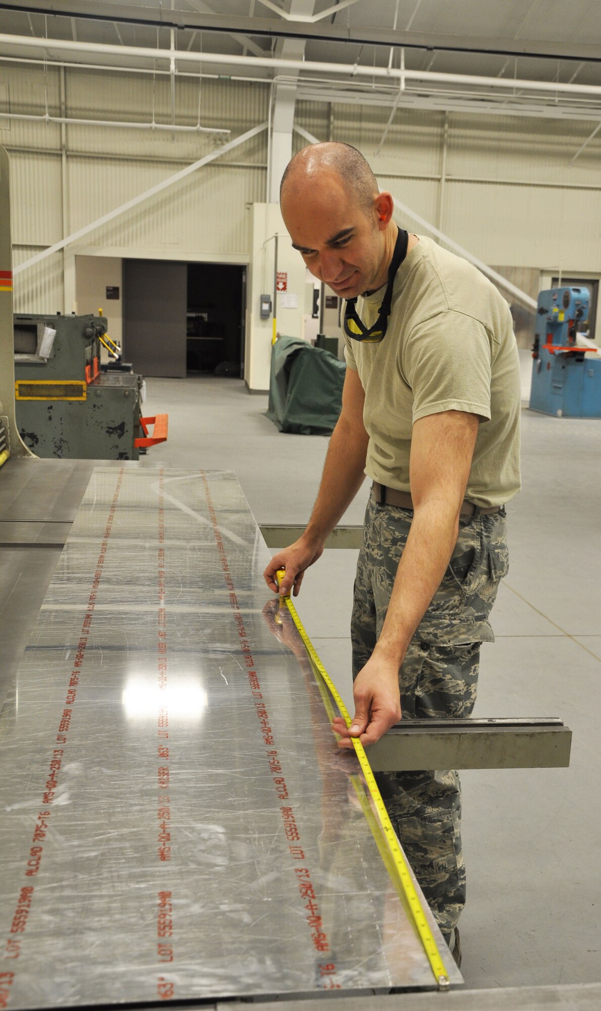 Tech. Sgt. John Barker, 931st Maintenance Squadron air reserve technician, carefully measures a piece of sheet metal before running it through a metal slicer at McConnell Air Force Base, Kan., Jan. 22, 2015.  Barker, who works in the Aircraft Structural Maintenance Shop, is helping upgrade the galleys used in the KC-135 Stratotankers.  (U.S. Air Force photo by Tech. Sgt. Abigail Klein) 