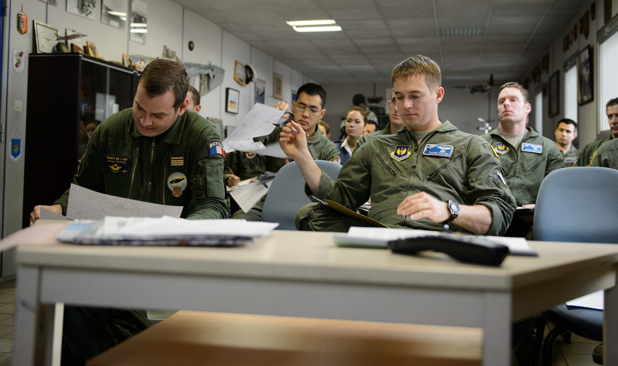 U.S. and French Airmen study maps and listen to a briefer prior to flying in a French-led formation as part of exercise Volfa 15-1 at Orleans - Bricy Air Base, France, Jan. 21, 2015. The exercise is designed to improve future operations. (U.S. Air Force photo/Senior Airman Armando A. Schwier-Morales)