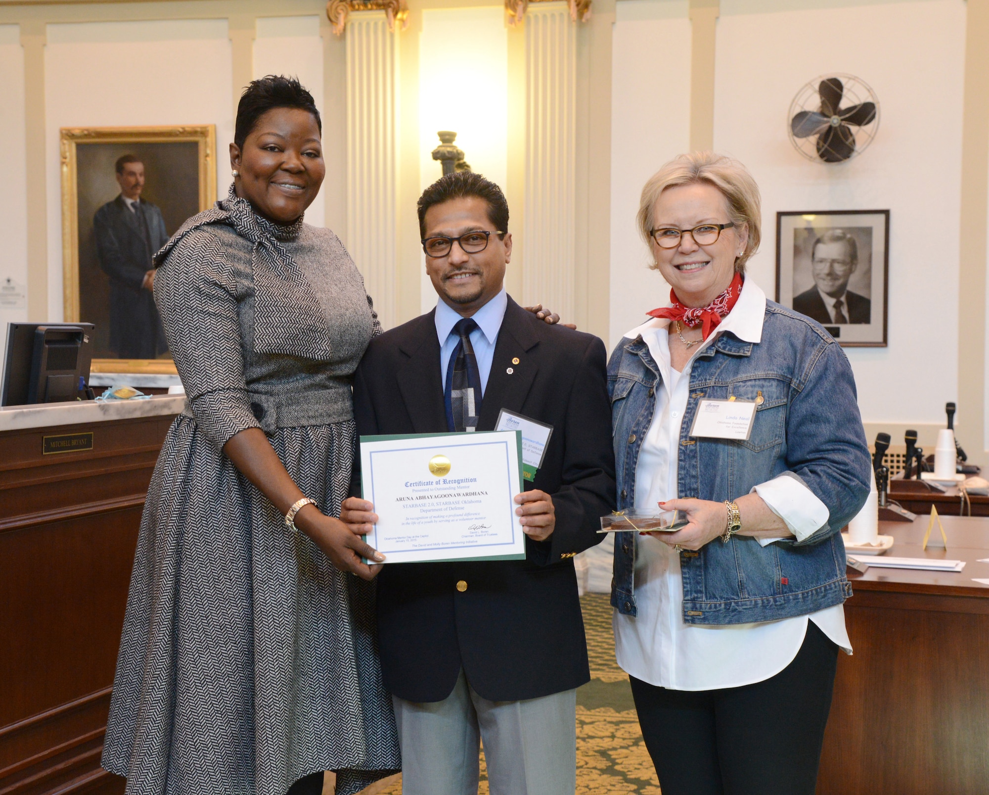 Aruna Abhayagoonawardhana, from the 72nd Civil Engineer Directorate, was recognized for being an outstanding mentor during Oklahoma Mentor Day at the State Capitol on Jan. 15. Mr. Abhayagoonawardhana is a lead mentor for STARBASE 2.0 at Carl Albert Middle School, helping children with Science, Technology, Engineering and Mathematics, or STEM, projects and teaching them character and leadership skills. The award was presented by Wanda Pratt, mother of Kevin Durant, left, and Linda Neal, president of the Oklahoma Foundation for Excellence. (Air Force photo by Kelly White)