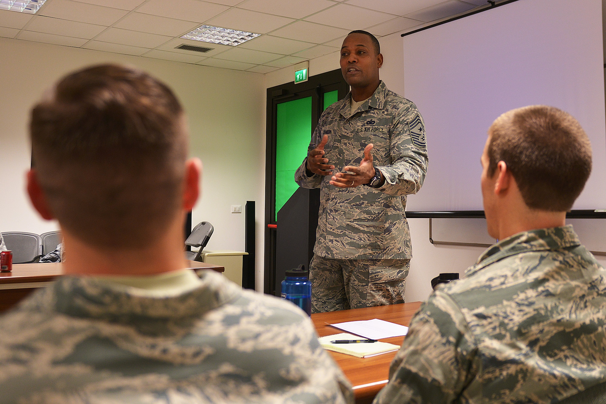 U.S. Air Force Chief Master Sgt. Anthony W. Johnson, 31st Fighter Wing command chief, speaks to two lieutenants during a new course for newly-appointed flight commanders and chiefs, Jan. 22, 2015, at Aviano Air Base, Italy. Twenty-two people attended the course, which included lieutenants, captains, majors, senior NCOs and a civilian. (U.S. Air Force photo by Airman 1st Class Ryan Conroy/Released)