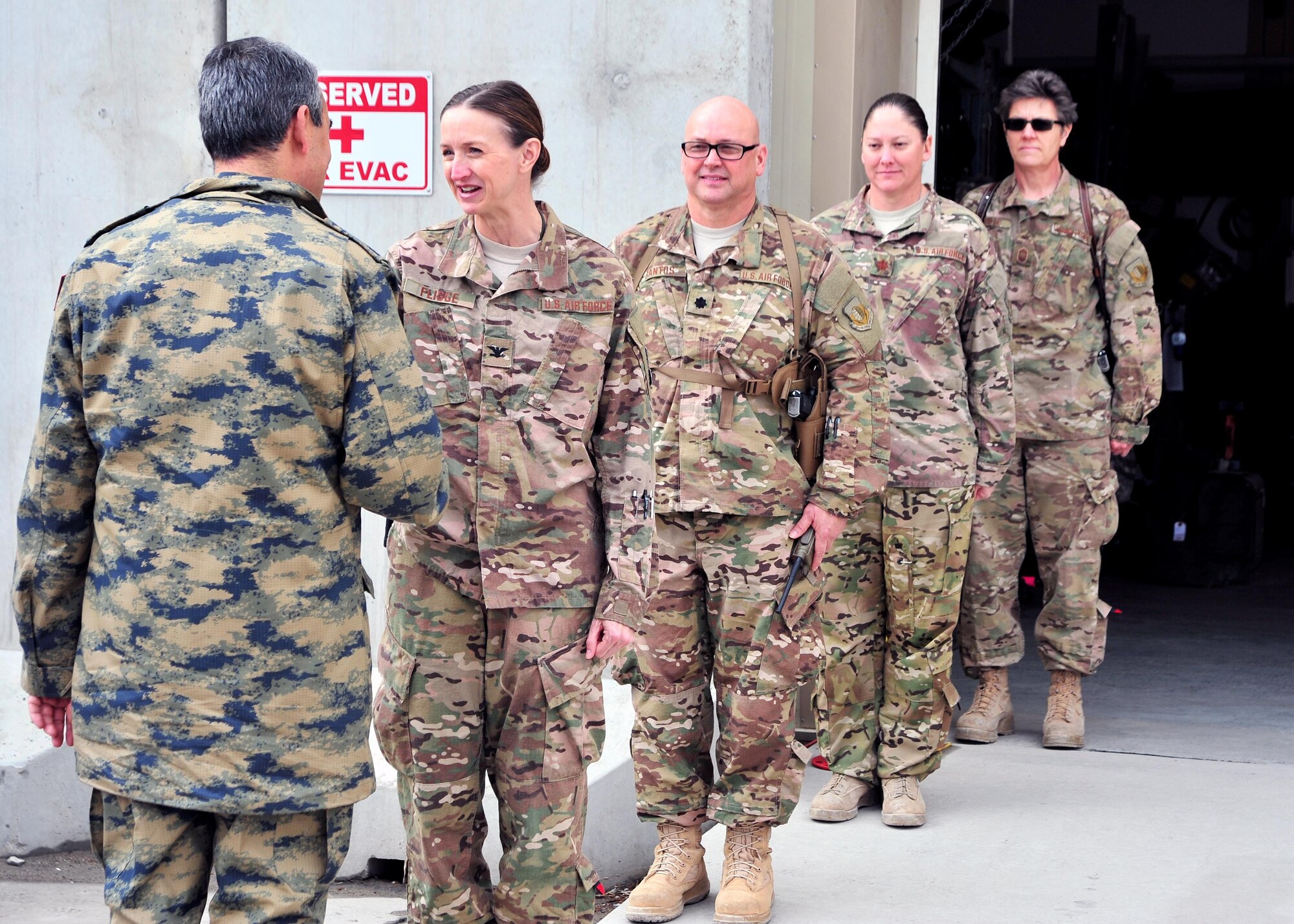Turkish Air Force Maj. Gen.  Mehmet Cahit Bakir, Commander of Kabul International Airport, shakes hands with U.S. Air Force Col. Anita Fligge, 455th Expeditionary Aeromedical Evacuation Squadron commander, during a tour Jan. 22, 2015 at Bagram Airfield, Afghanistan. During the tour, Bakir had the opportunity to meet with 455th Air Expeditionary Wing leadership and become better acquainted with Air Force assets and squadrons here. (U.S. Air Force photo by Staff Sgt. Whitney Amstutz/released)